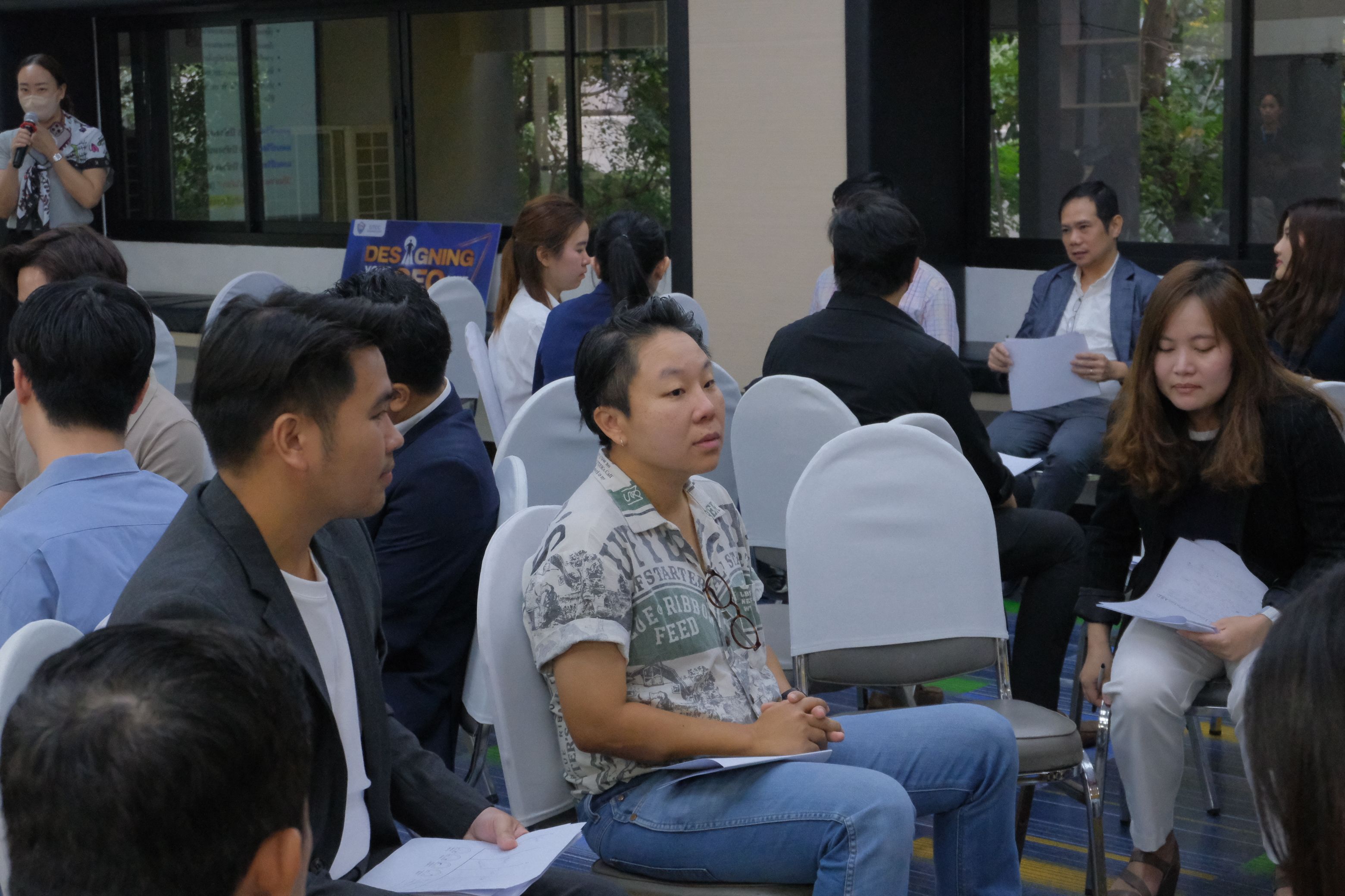 Attendees listen attentively during a professional event or seminar, focusing on a speaker.