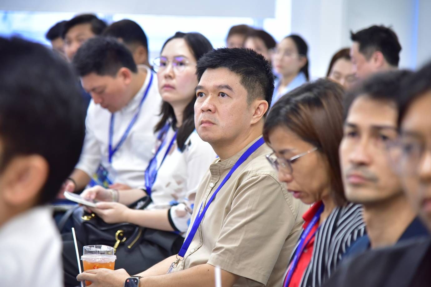 Diverse professionals attentively listening in an audience at a conference or seminar.