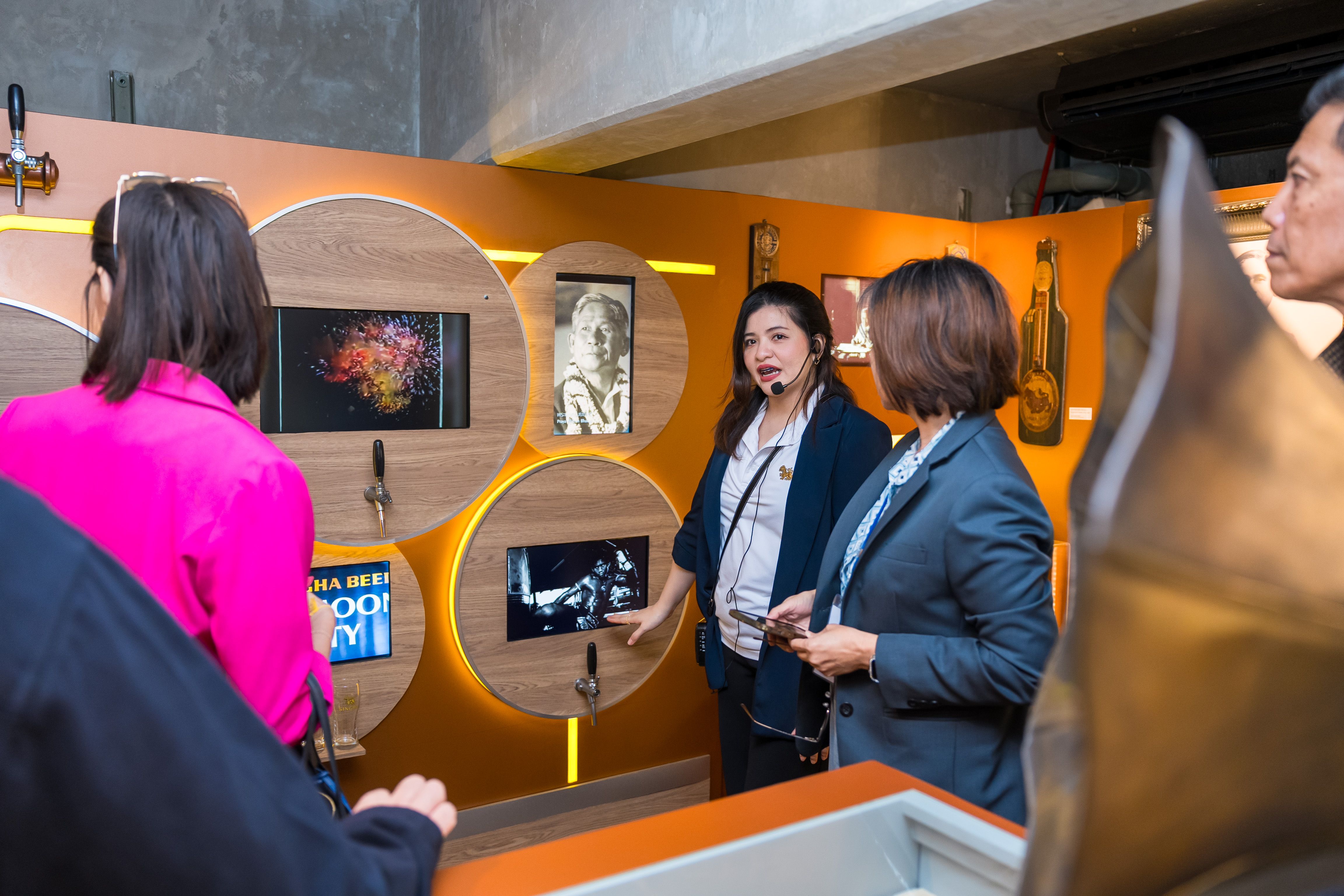 Tour guide explains interactive museum exhibits to a small group of visitors.