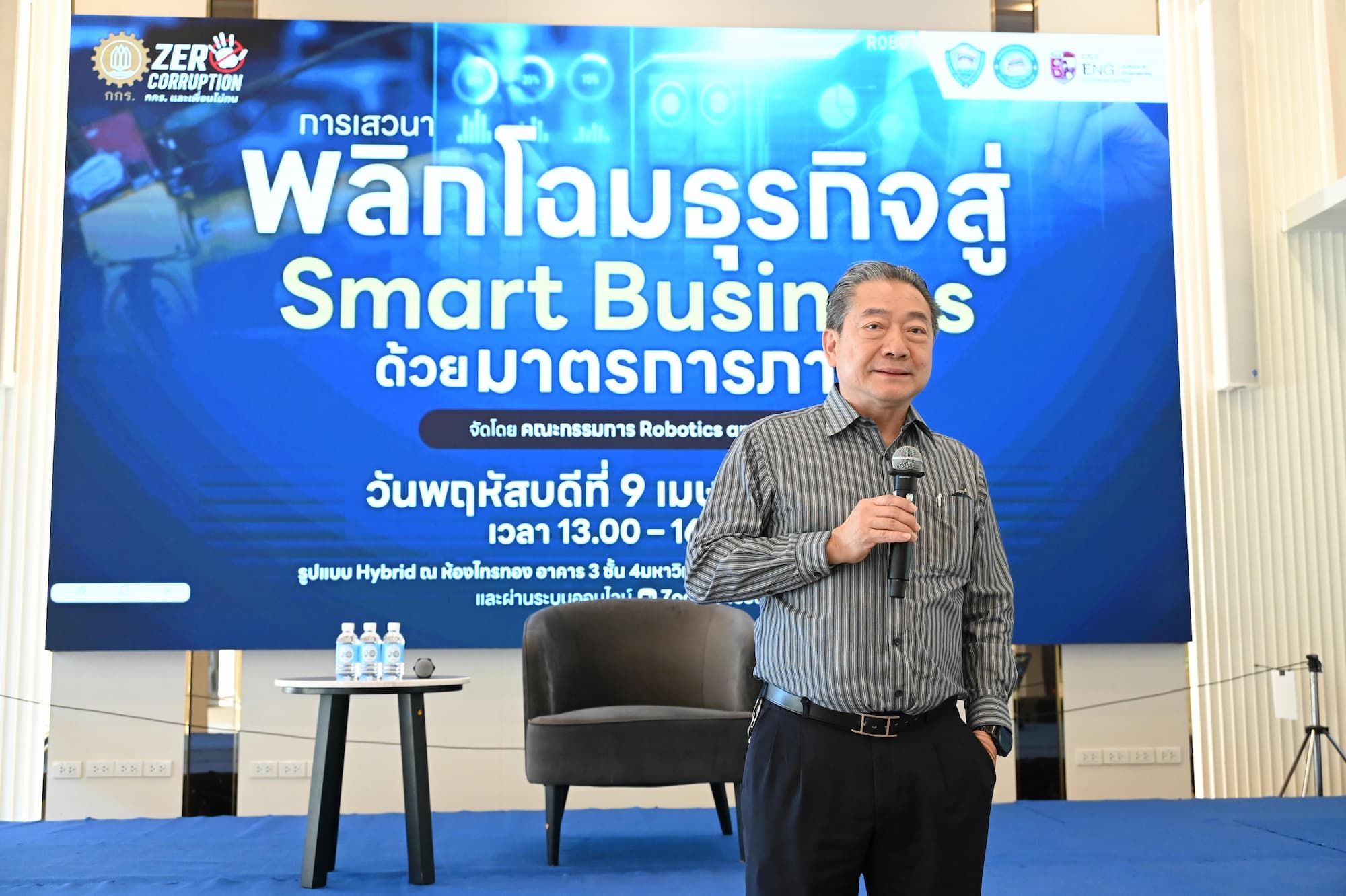 Man in grey shirt presents 'Smart Business' on blue backdrop with Thai text.