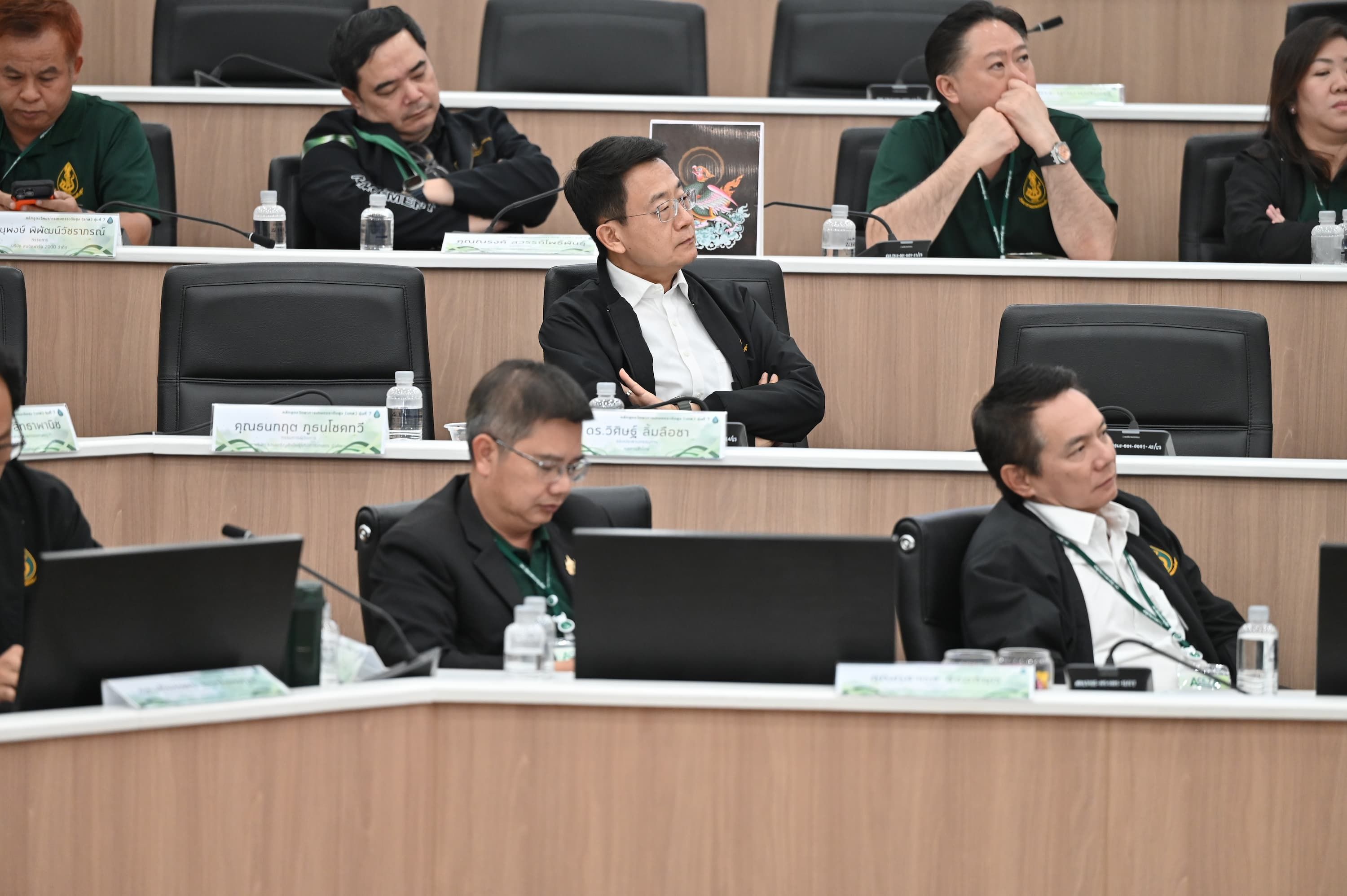 Several professionals seated in a tiered auditorium attending a conference.