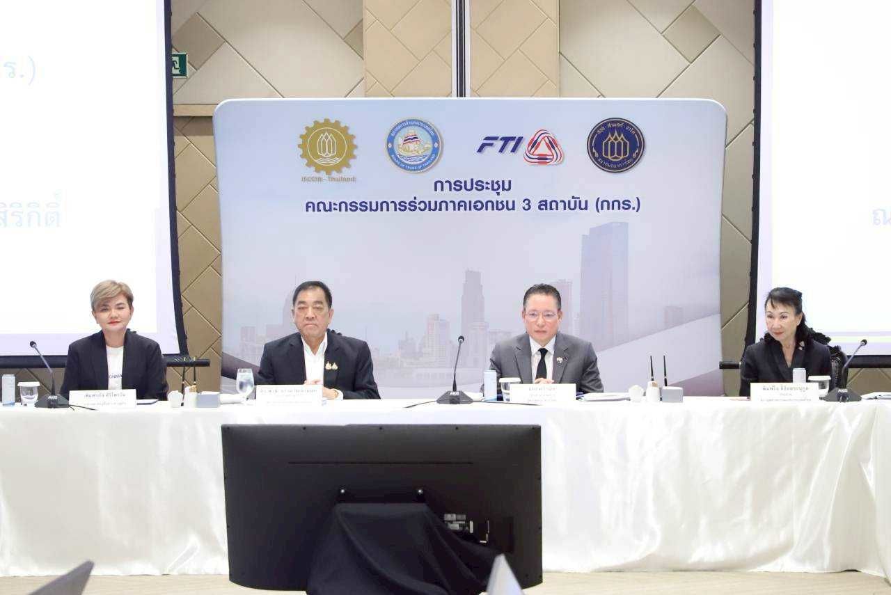 Four professionals sit at a conference table with microphones in front of a branded white backdrop.