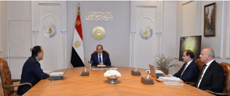 Egyptian President Abdel Fattah El-Sisi meets with three men at a large conference table.
