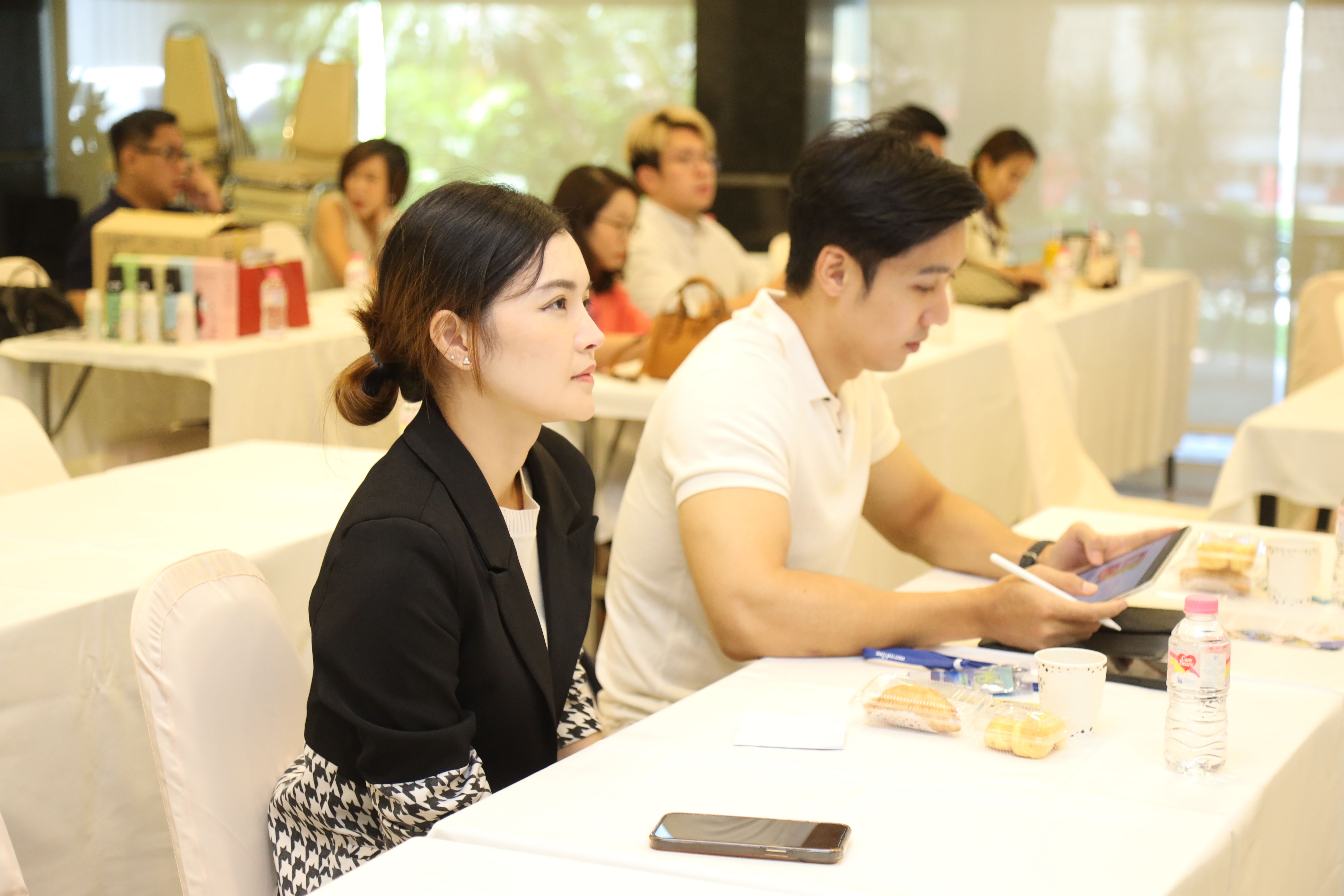 Attendees, including a woman in a black blazer, participate in a professional workshop.