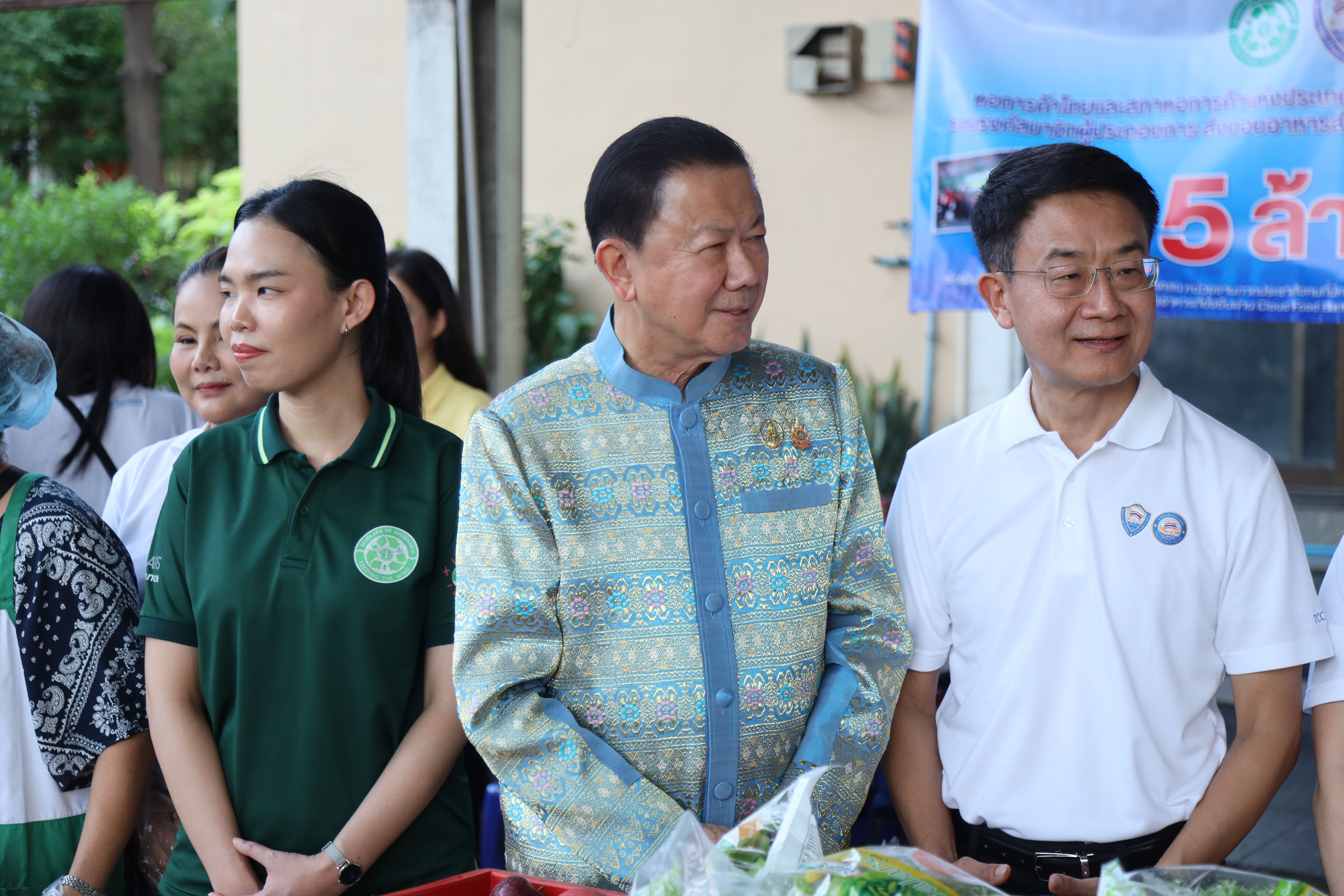 A woman and two men stand attentively side-by-side, looking towards the right.