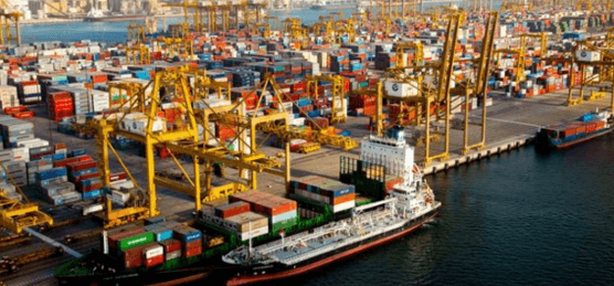 Aerial view of a bustling shipping port with a cargo ship and numerous colorful containers.