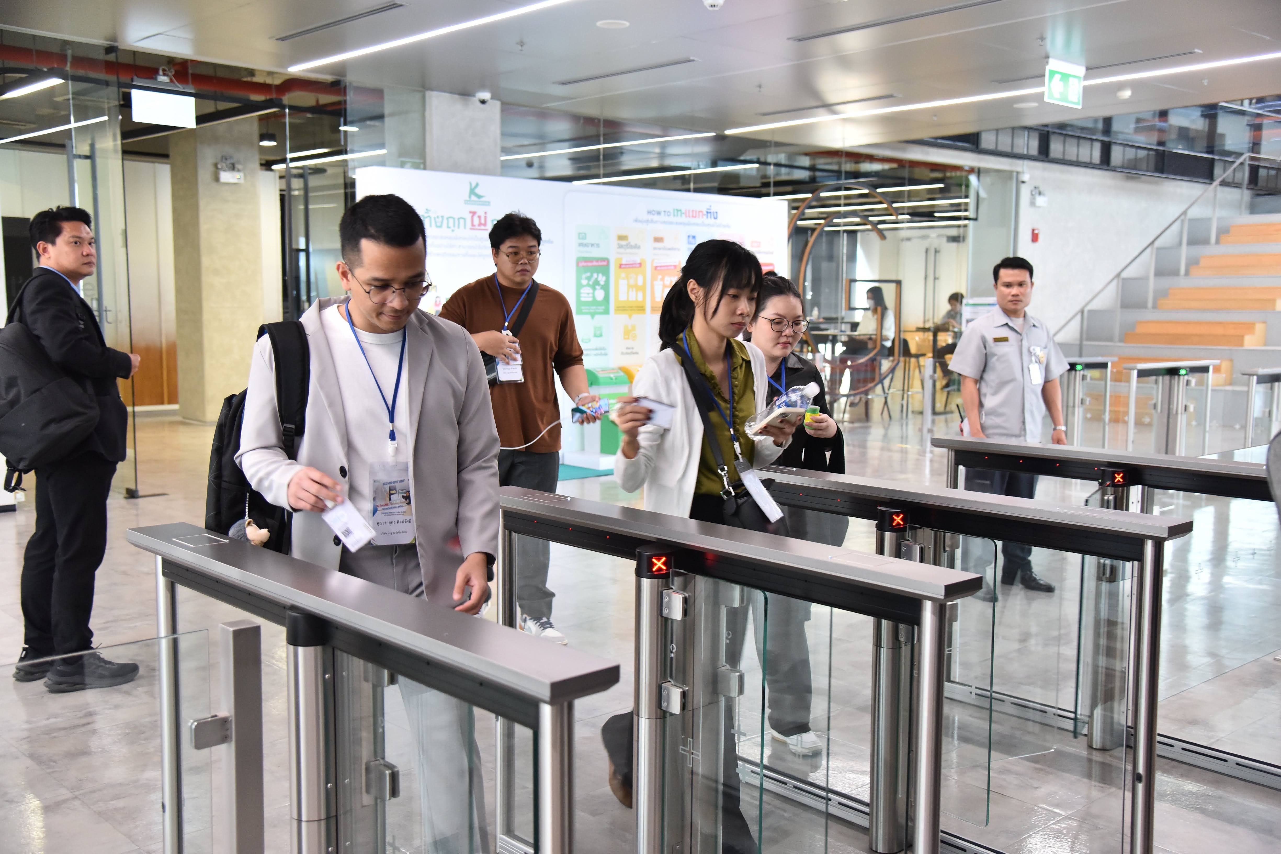 Attendees scan passes at modern turnstiles in a brightly lit indoor venue entrance.