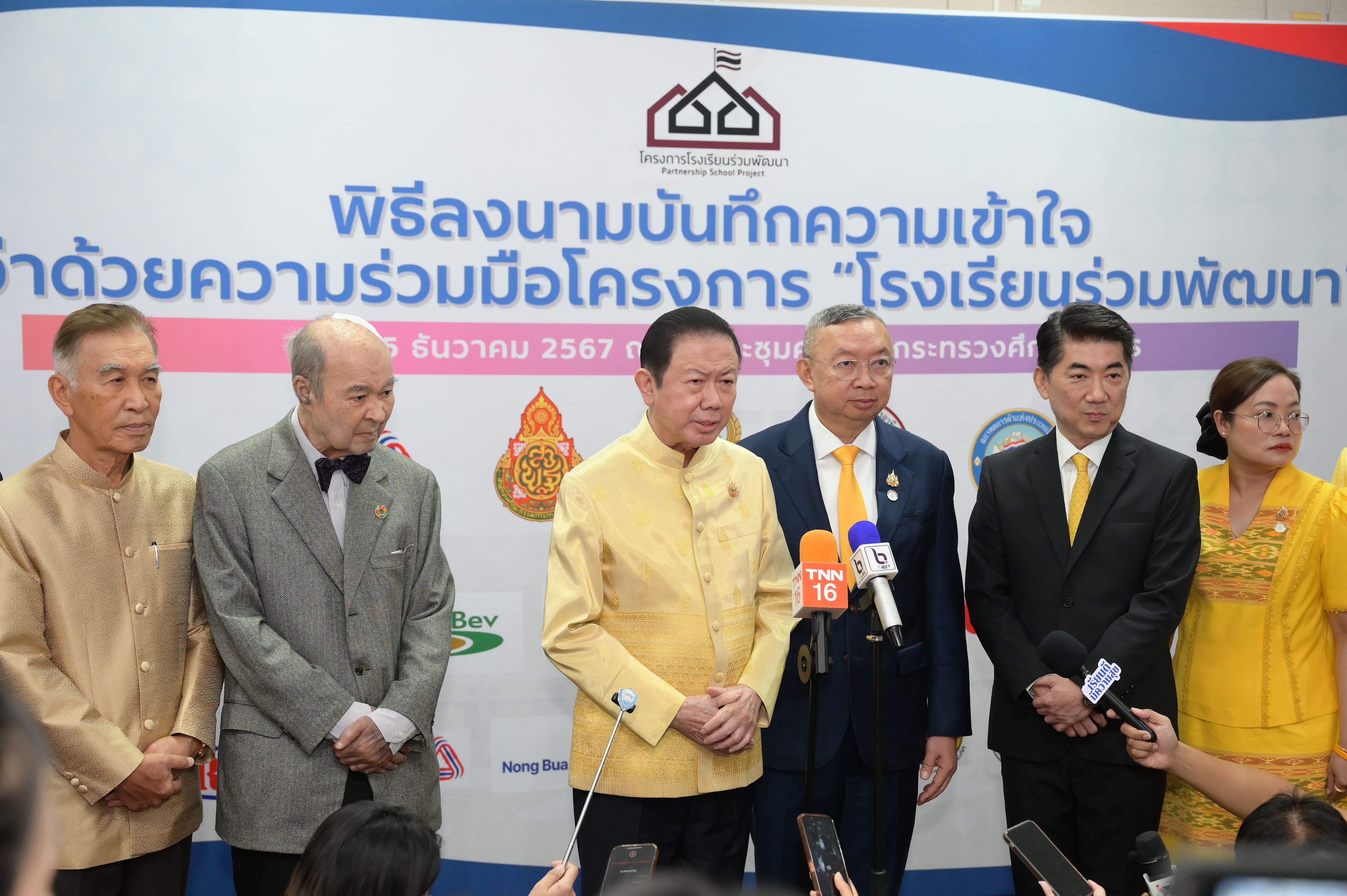 Group of officials at a signing ceremony for a co-developed schools project.