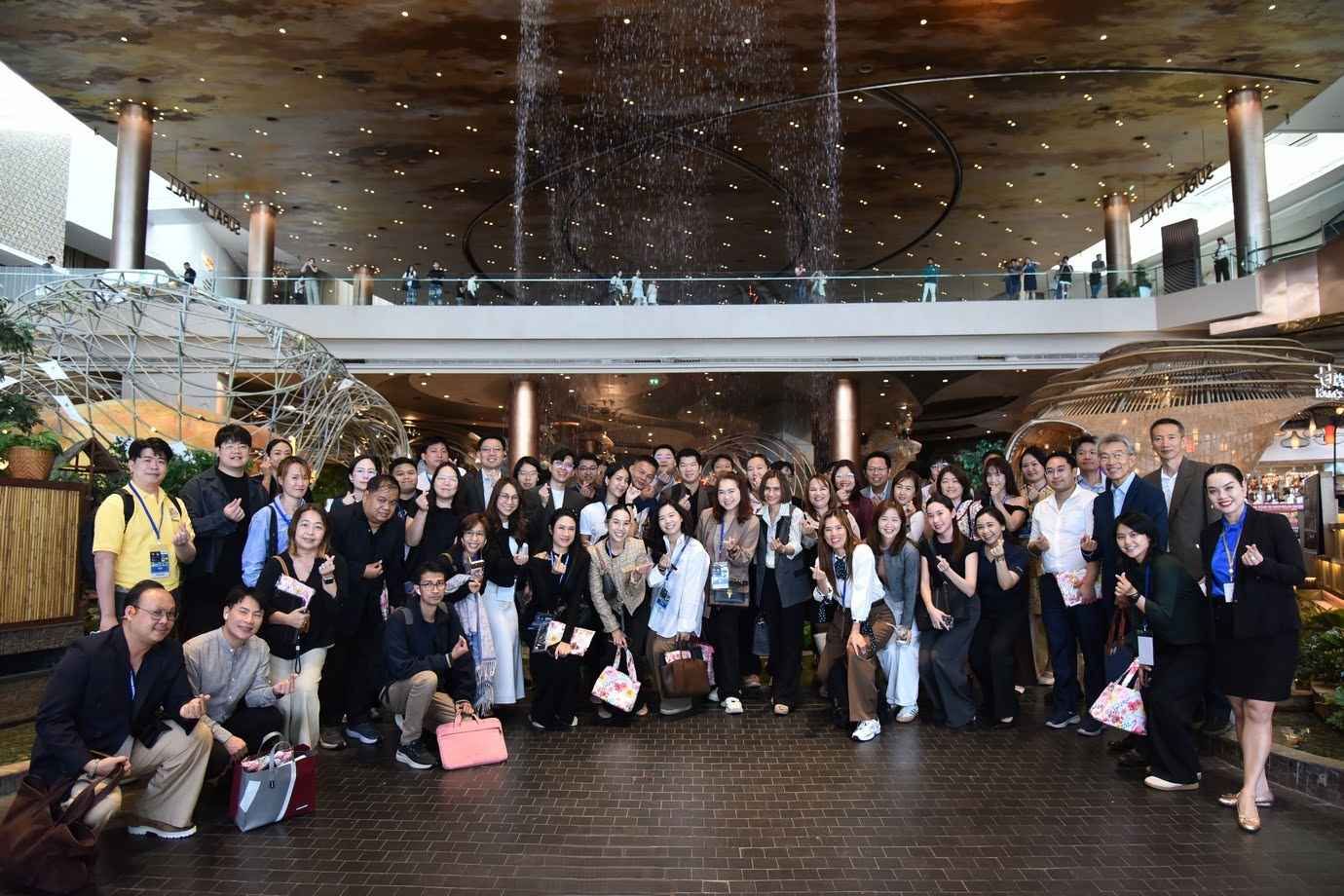 A large group of diverse professionals posing for a photo indoors at a conference venue.