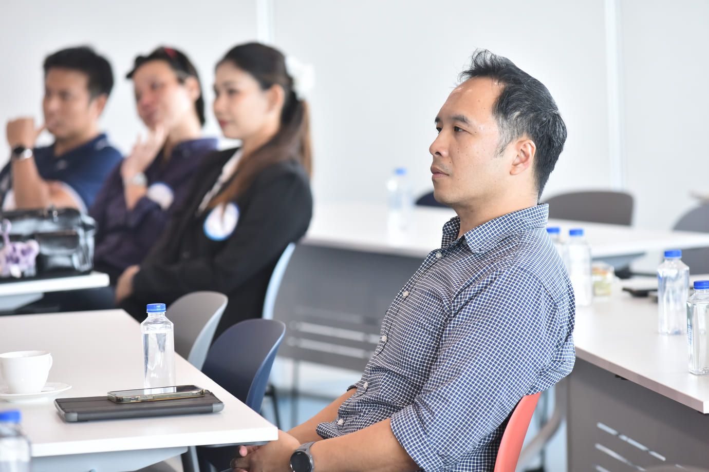 Man in a blue shirt attentively listening during a professional seminar.