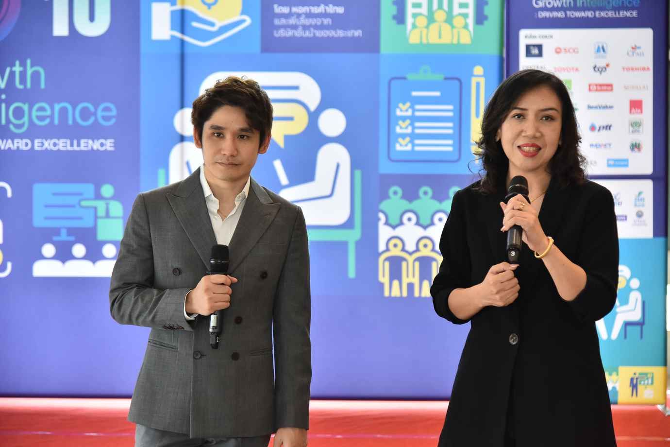 Man and woman holding microphones present at a professional event.