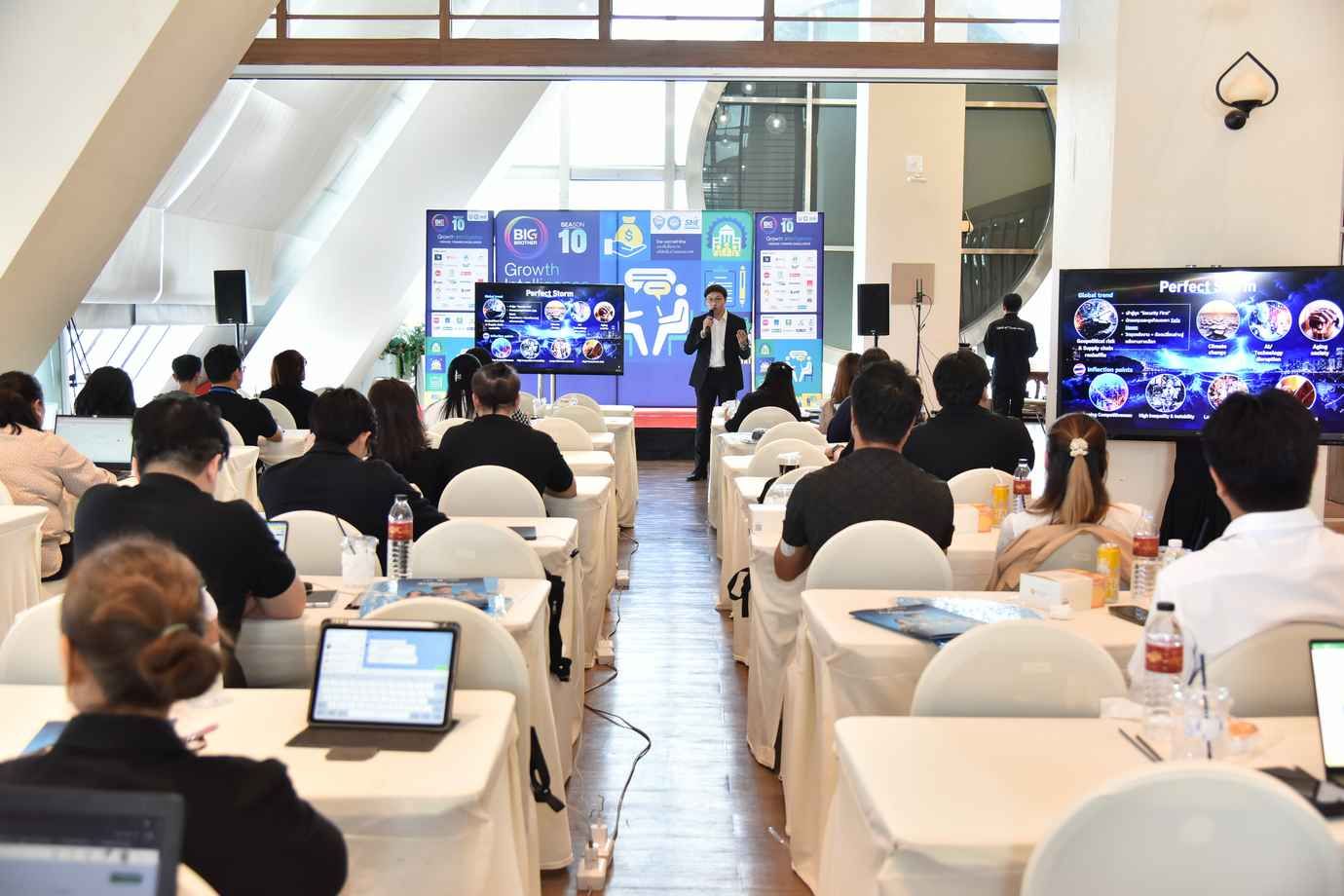 A speaker presents to an in-person audience and virtual attendees at a hybrid conference.