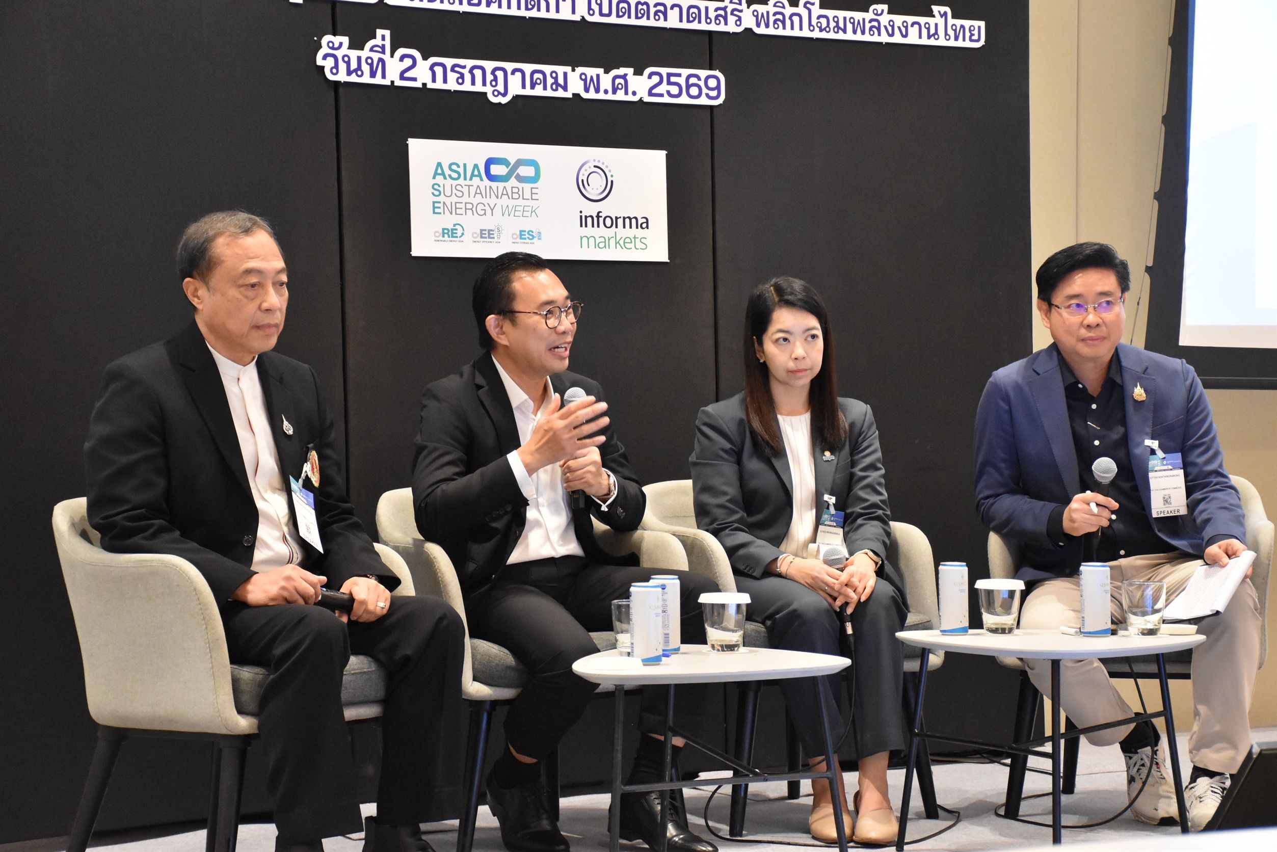Four panelists on stage discussing, with one man actively speaking and gesturing.