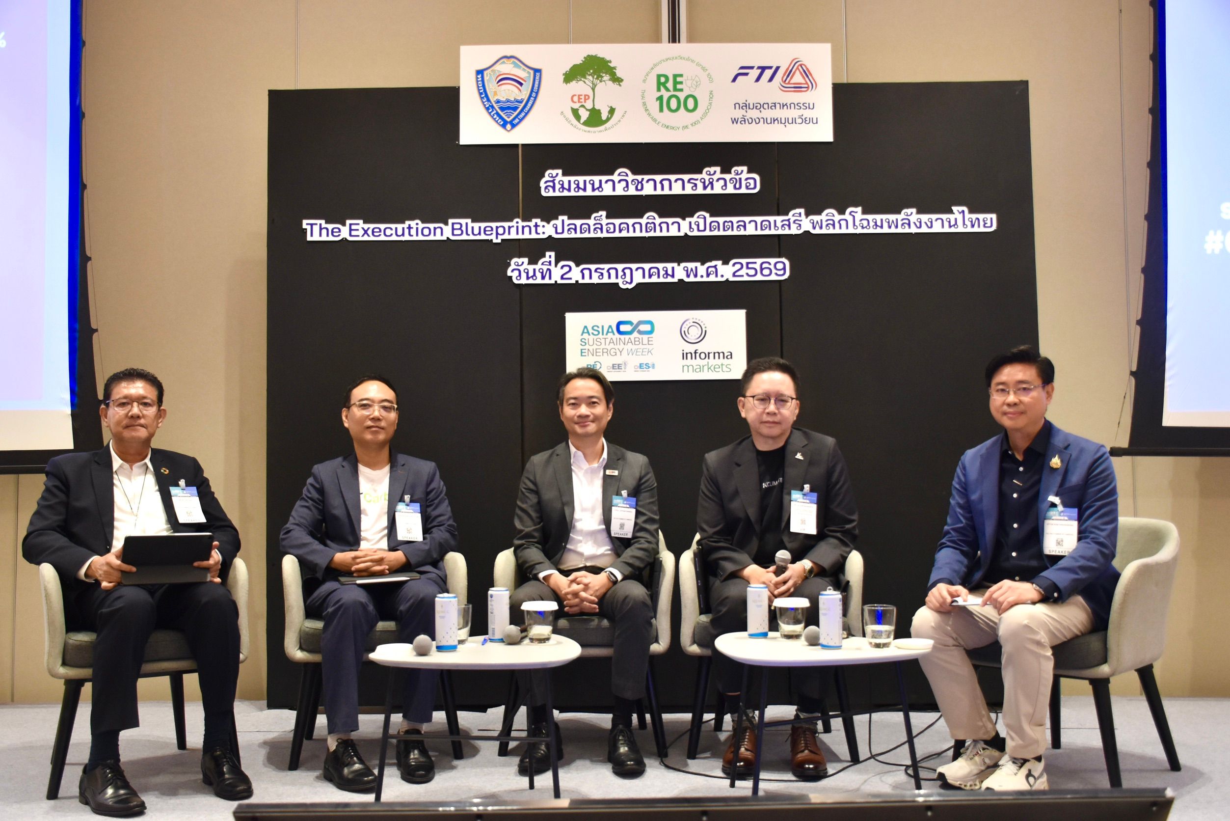 Five men sit on a stage as panelists during a professional event.