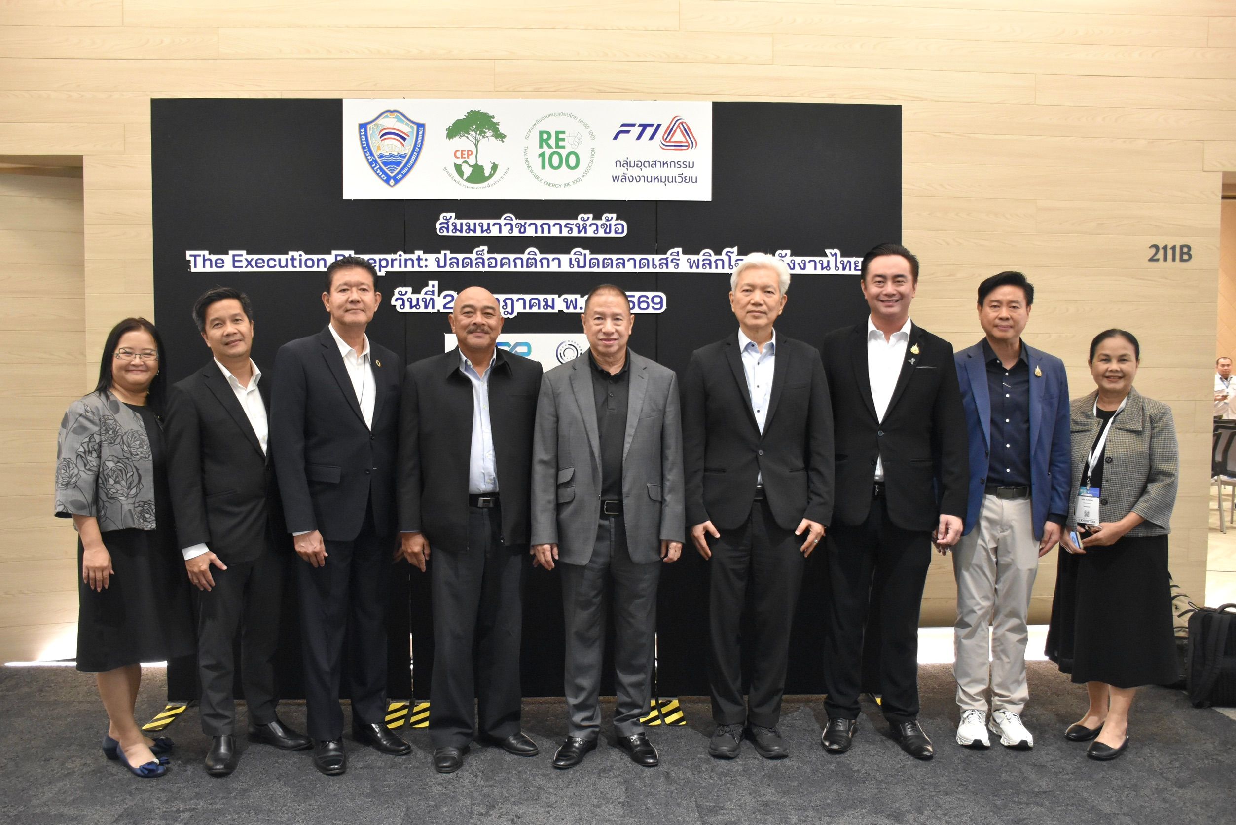 Group of professionals posing for a photo in front of a branded event backdrop.