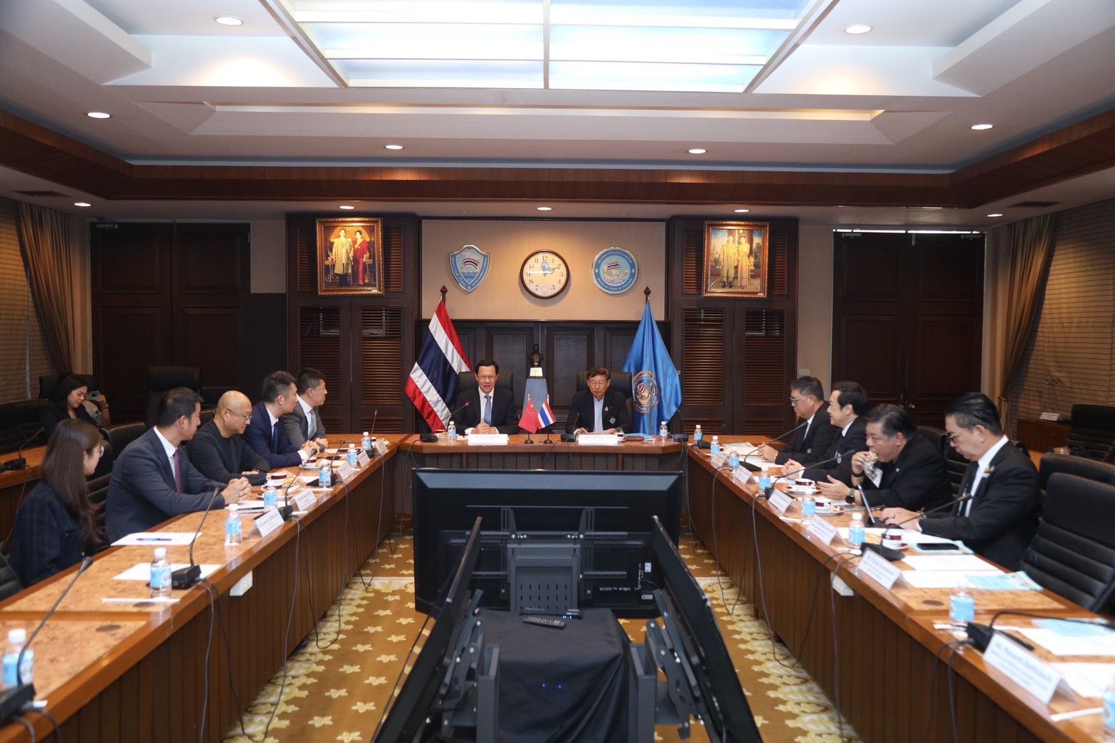 Formal diplomatic meeting with Thai officials and delegates around a large conference table.