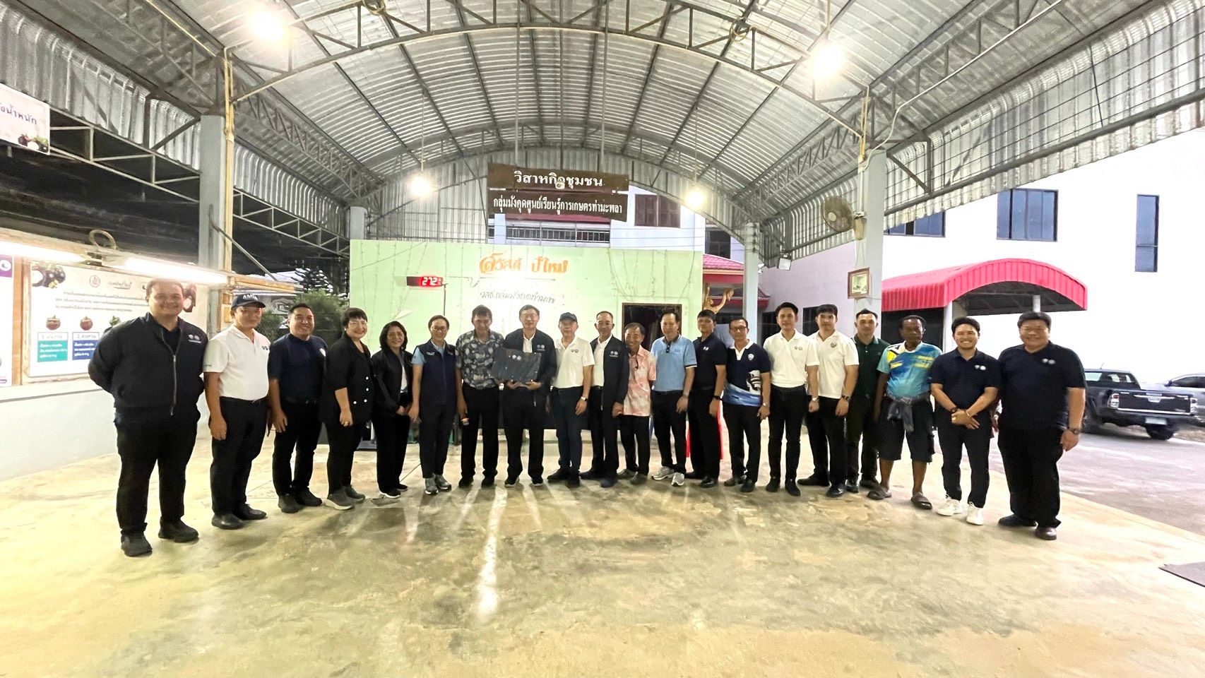 A diverse group of professionals stands in a large indoor facility, posing for a photograph.