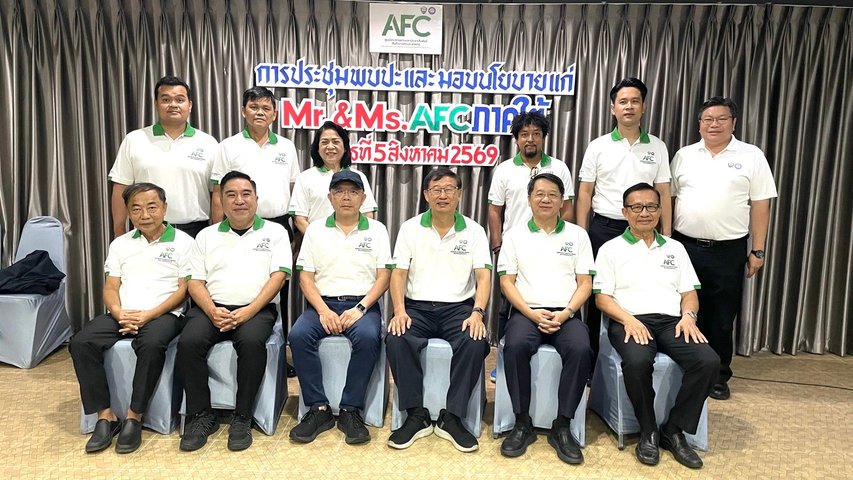 Group of men and women in white AFC polo shirts posing for a photo.