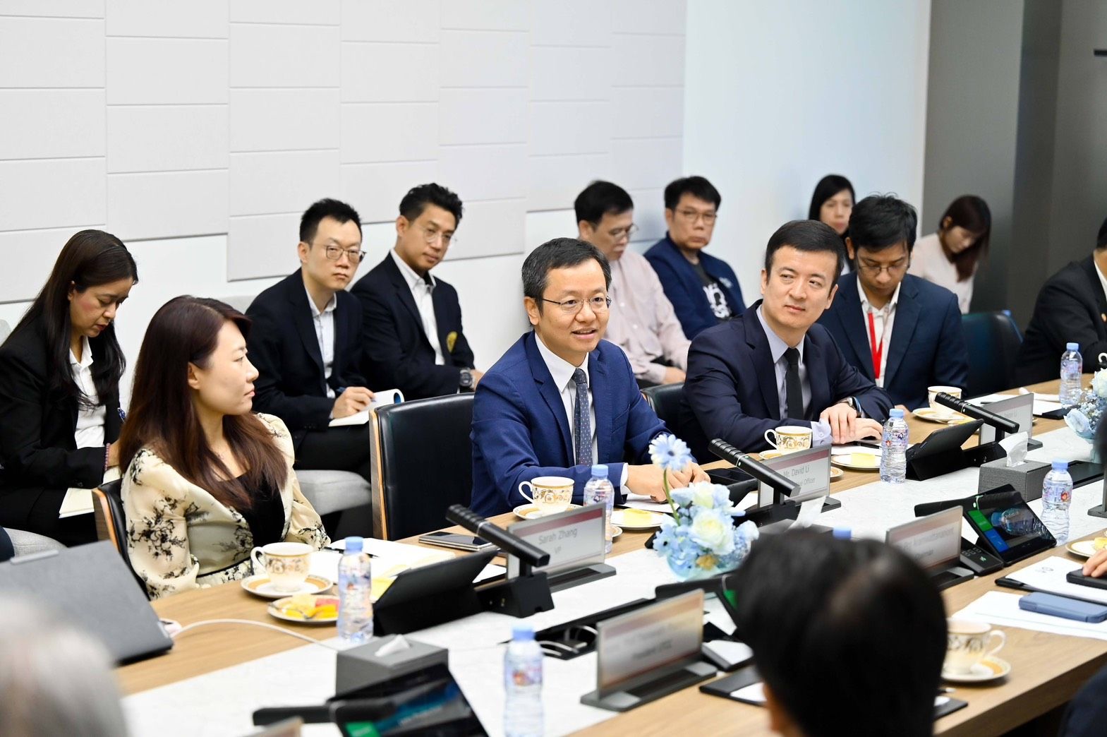 Professionals seated around a conference table engaged in a serious business meeting.