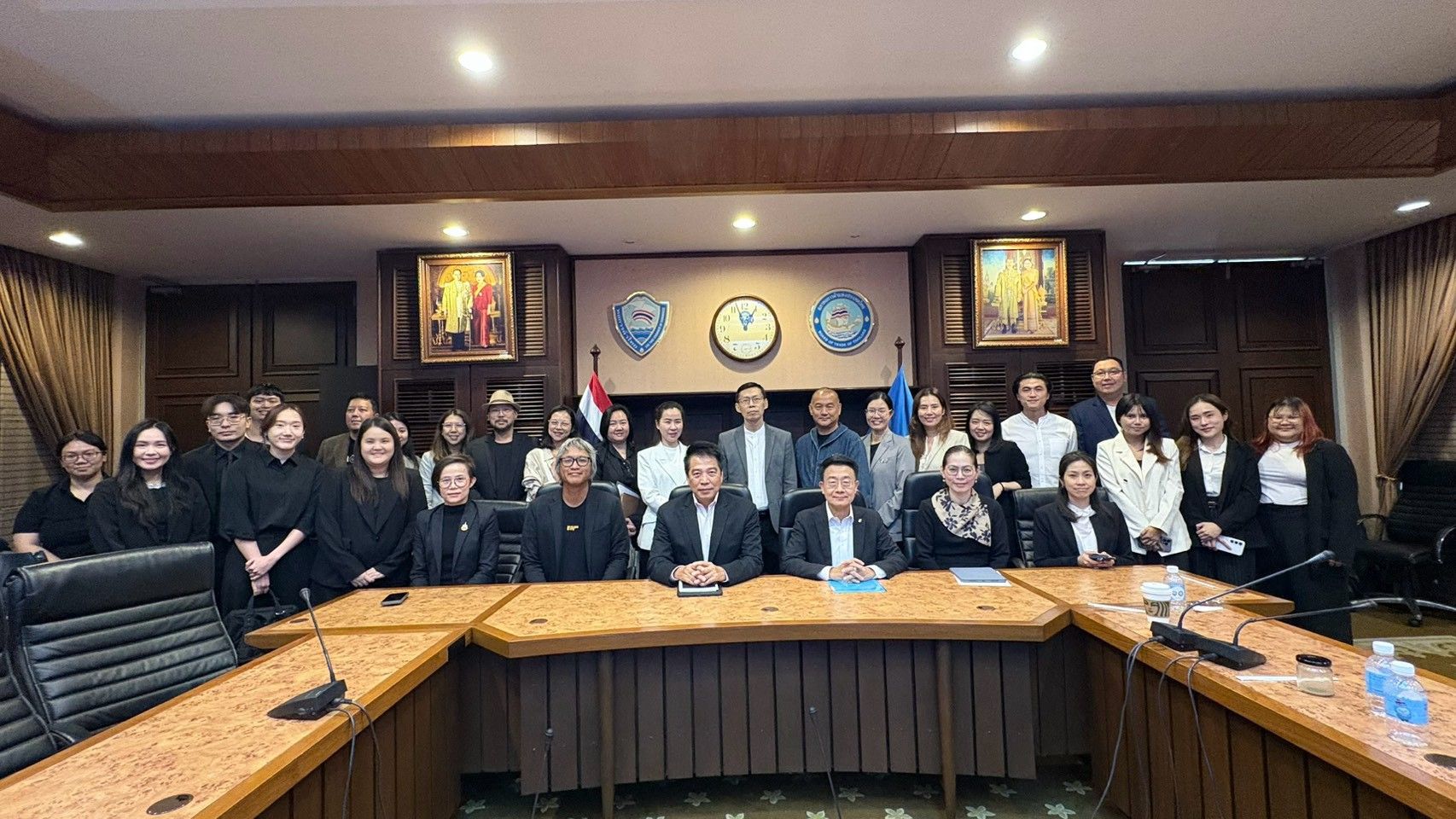 Group of legal professionals and officials pose in a formal conference room.