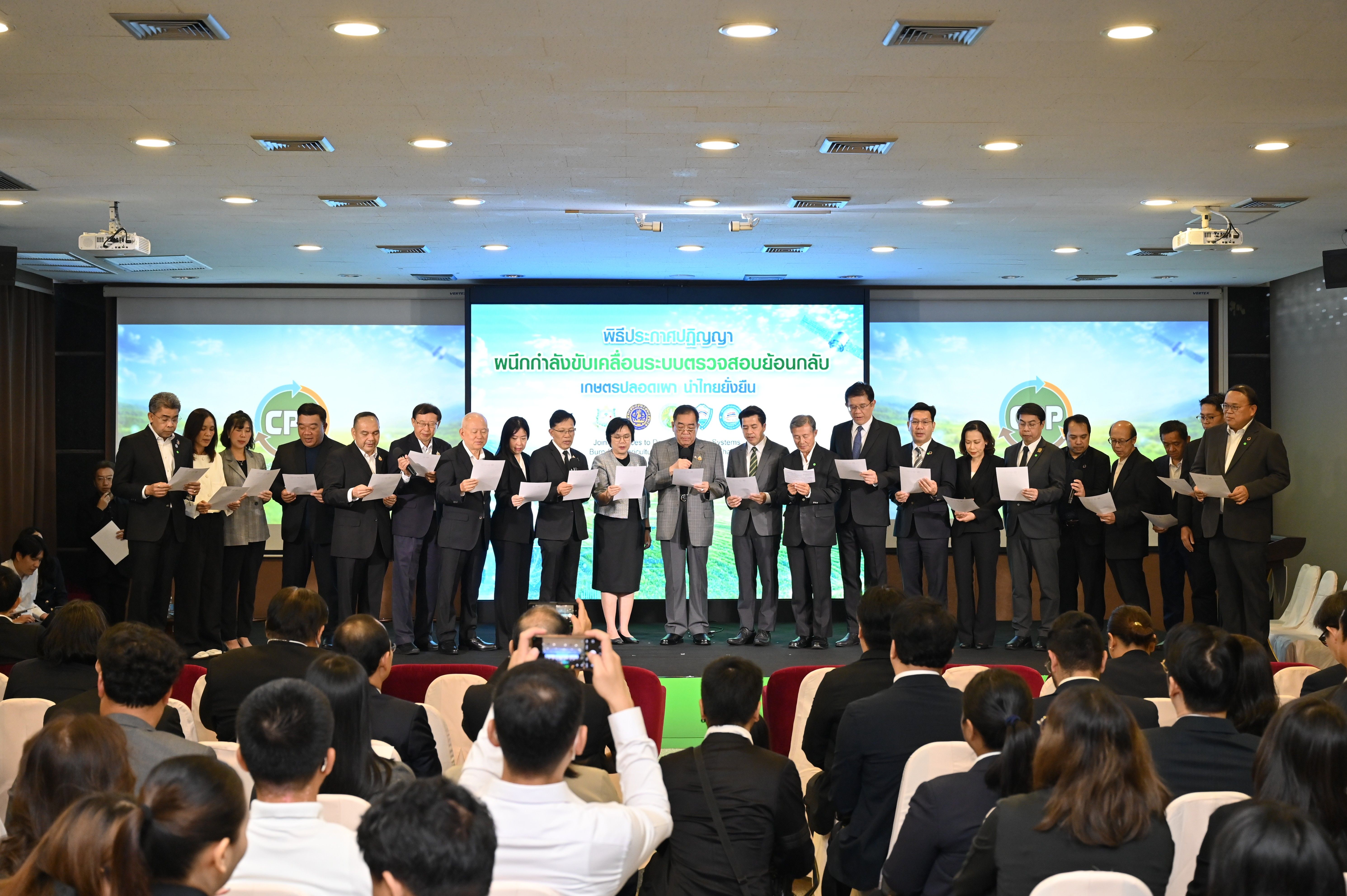 Formal group on stage holding certificates in front of an audience at an event.