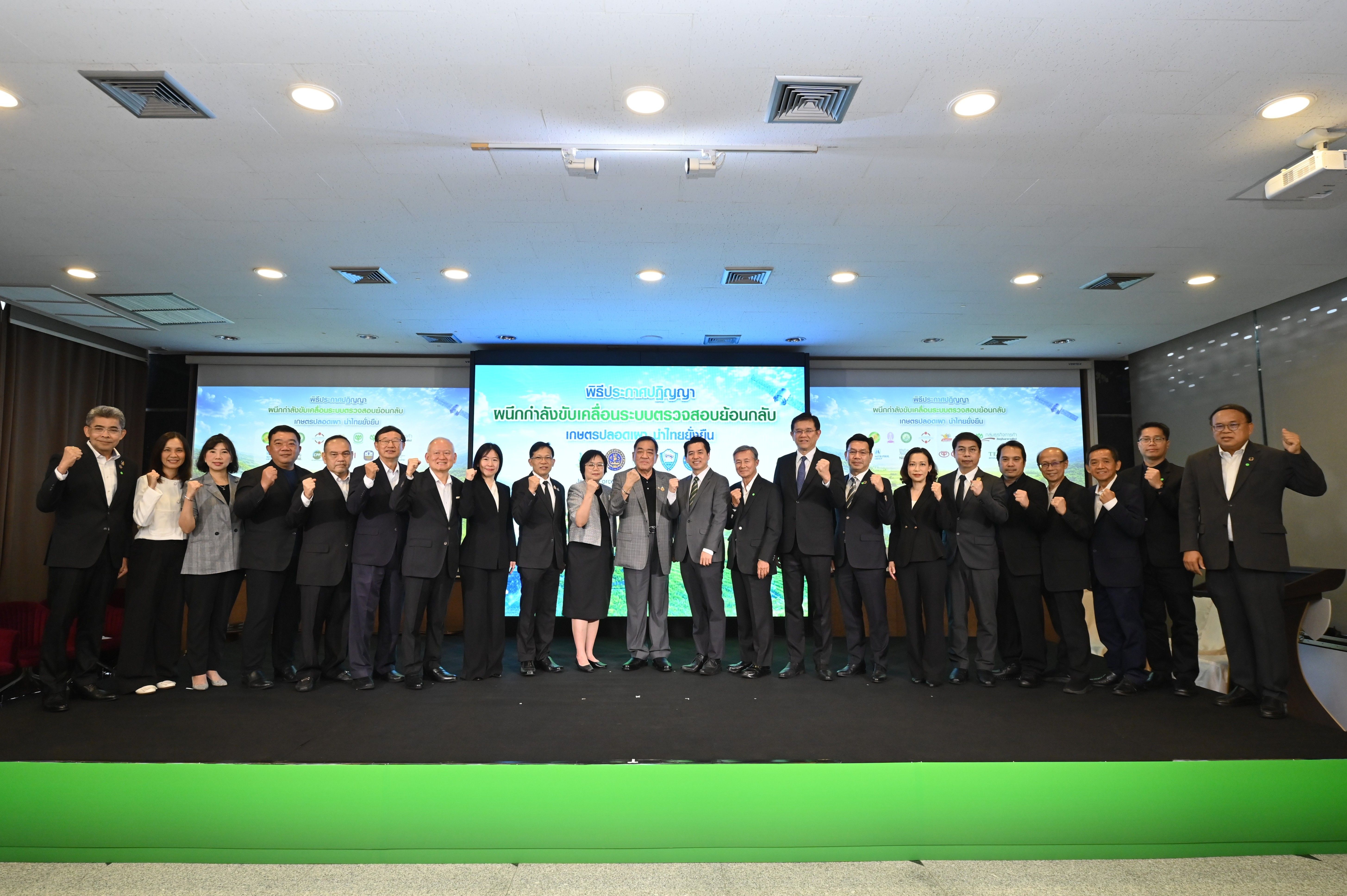 A large group of professionals pose on stage, many giving a thumbs-up gesture.