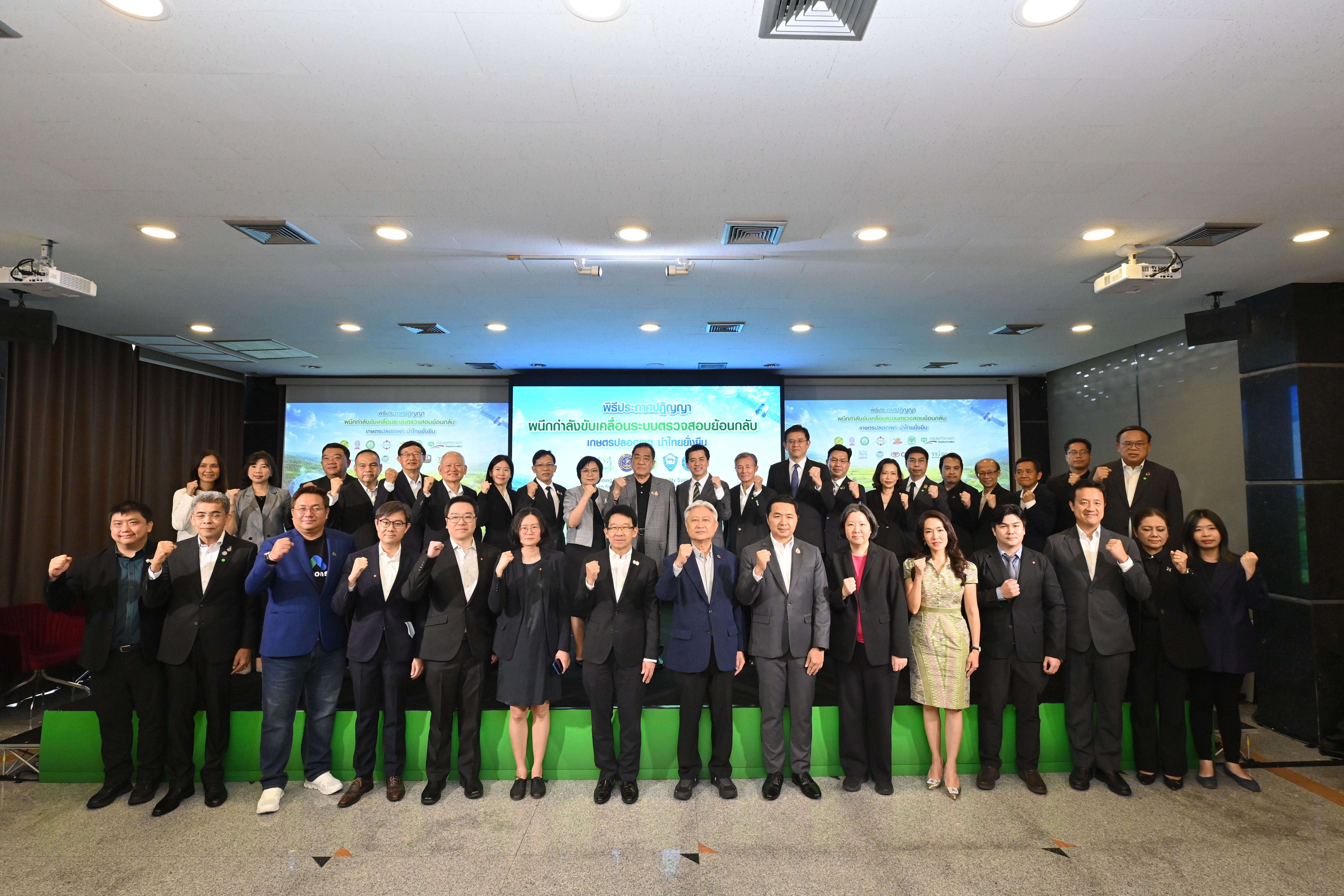 Large group of business professionals in formal attire posing for a photo at an indoor event.