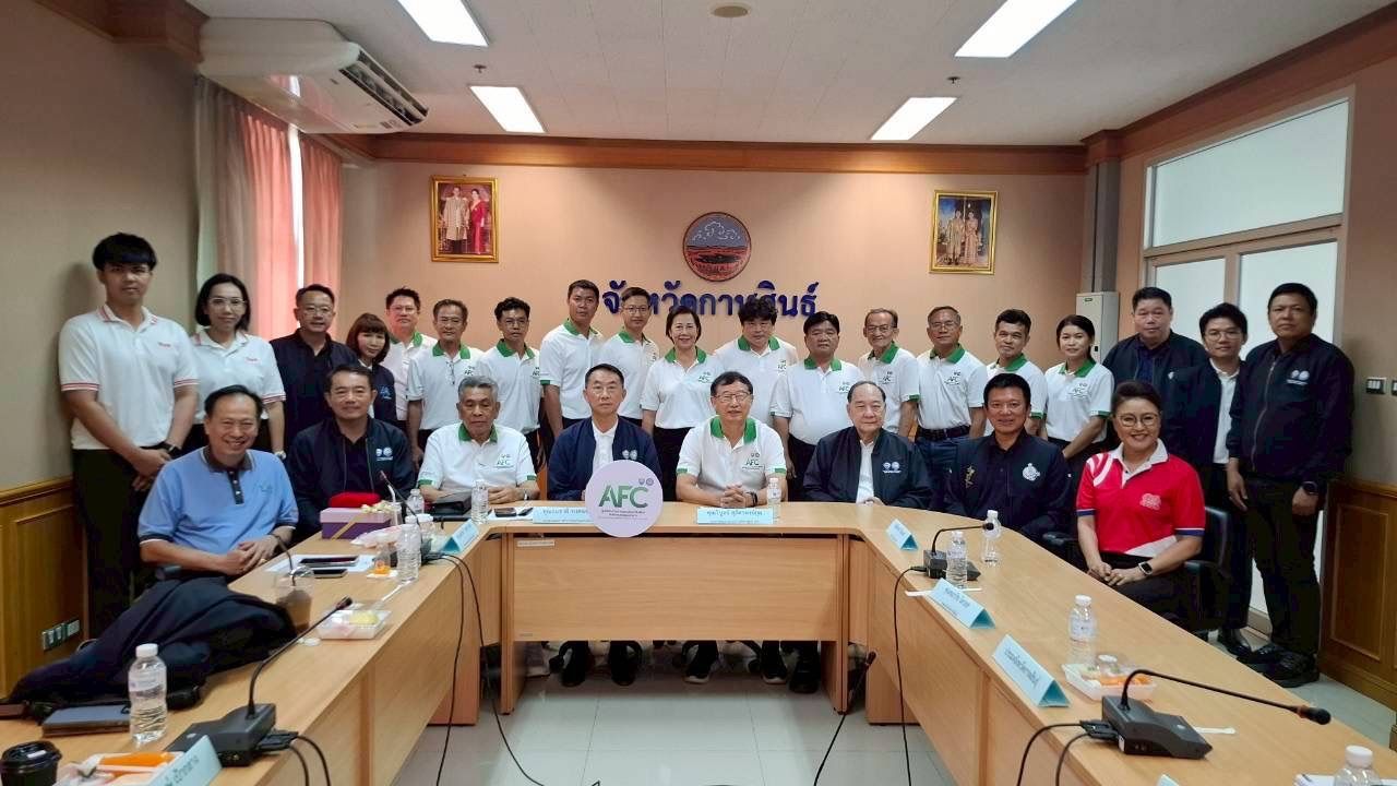Group of professionals seated and standing in a conference room during a meeting.