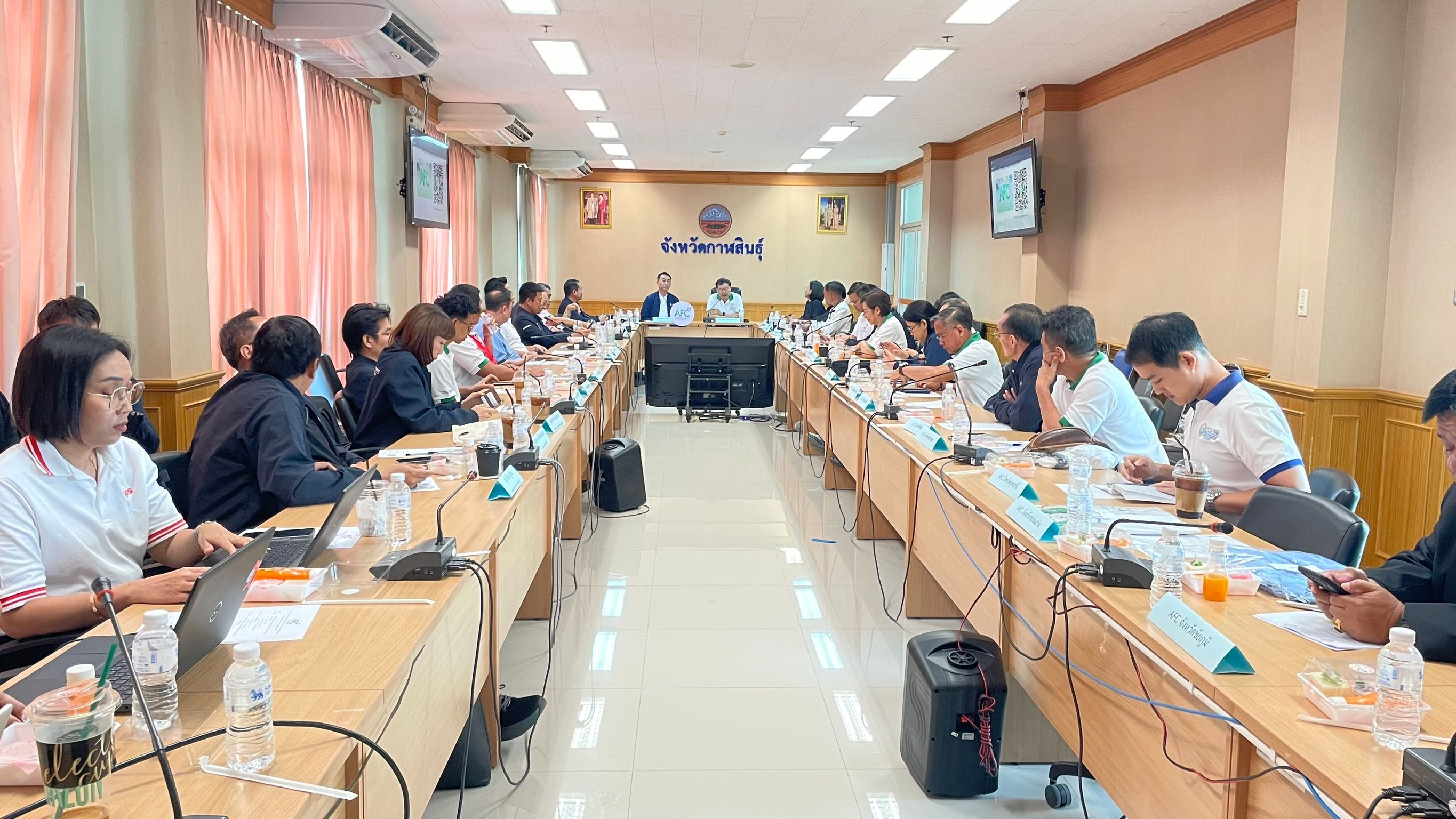 Professionals collaborate at a long conference table during a formal meeting.