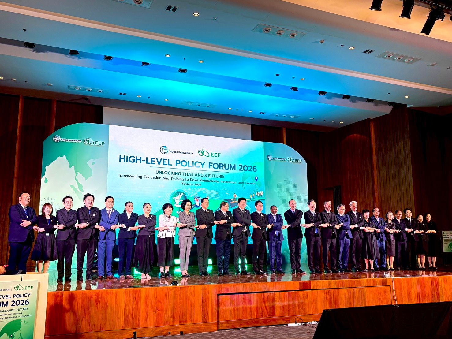 Professionals on stage at a 'HIGH-LEVEL POLICY FORUM' event.