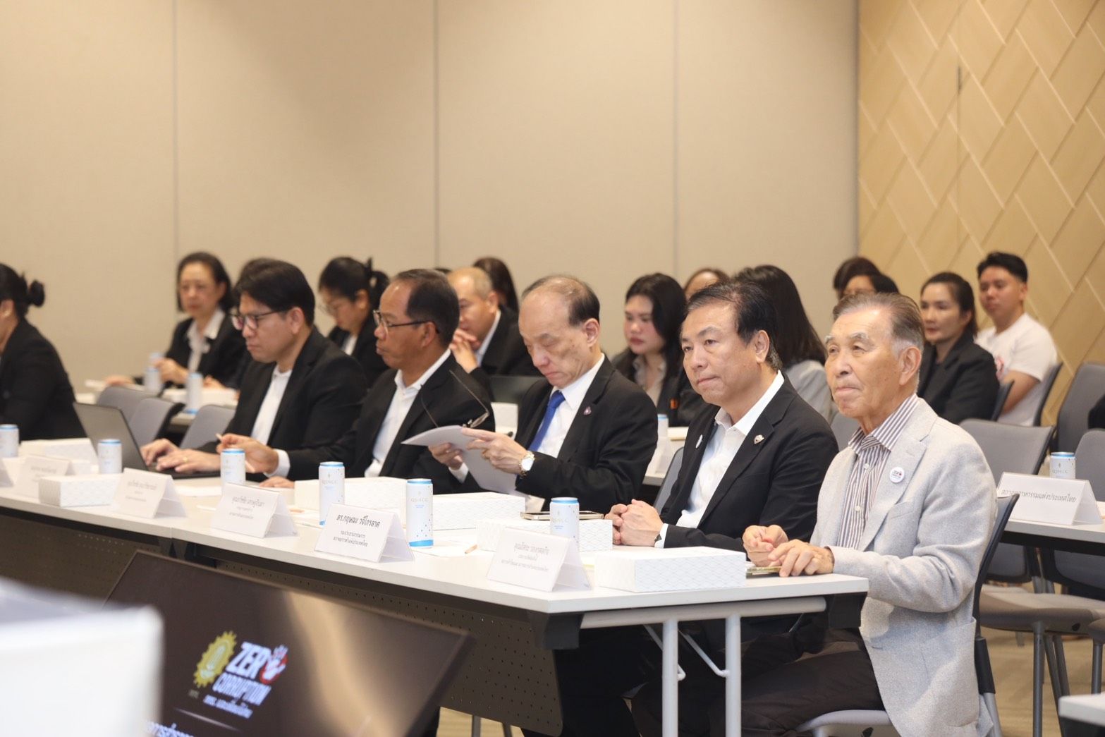A group of professionals in suits attending a conference or business meeting.
