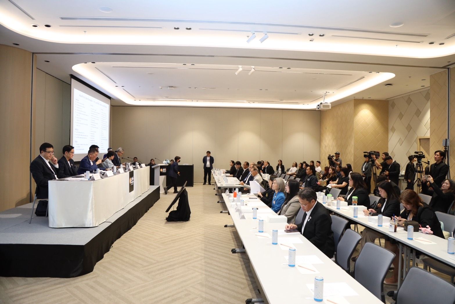 Attendees observe a presentation in a modern, well-lit conference room.