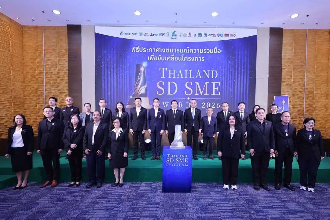 Large group of professionals posing before a 'THAILAND SD SME' event banner.