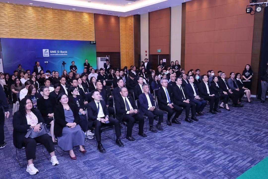 Large audience seated in a modern conference room, ready for a presentation.