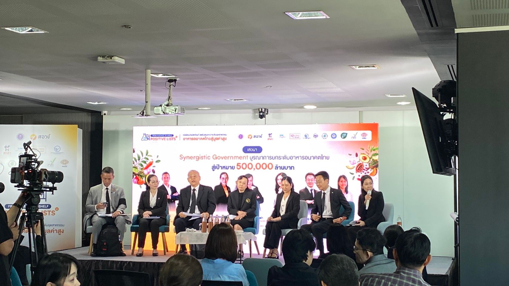 Six panelists discuss business on stage with "share 500,000 euros" on screen.