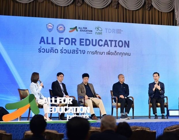 Panelists on stage discussing 'All for Education' with a large screen behind them.
