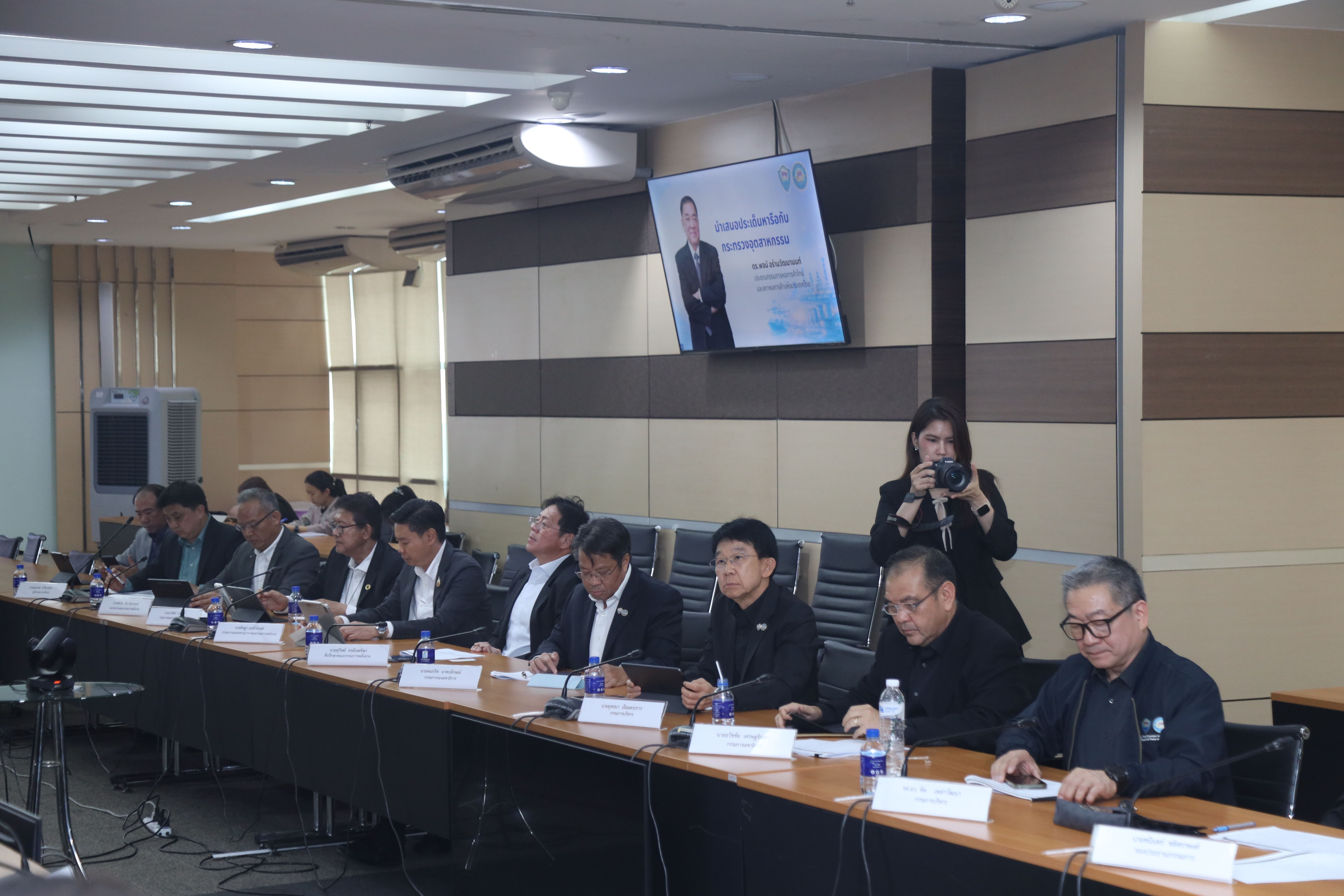 Group of professionals attending a meeting in a conference room with a presenter.