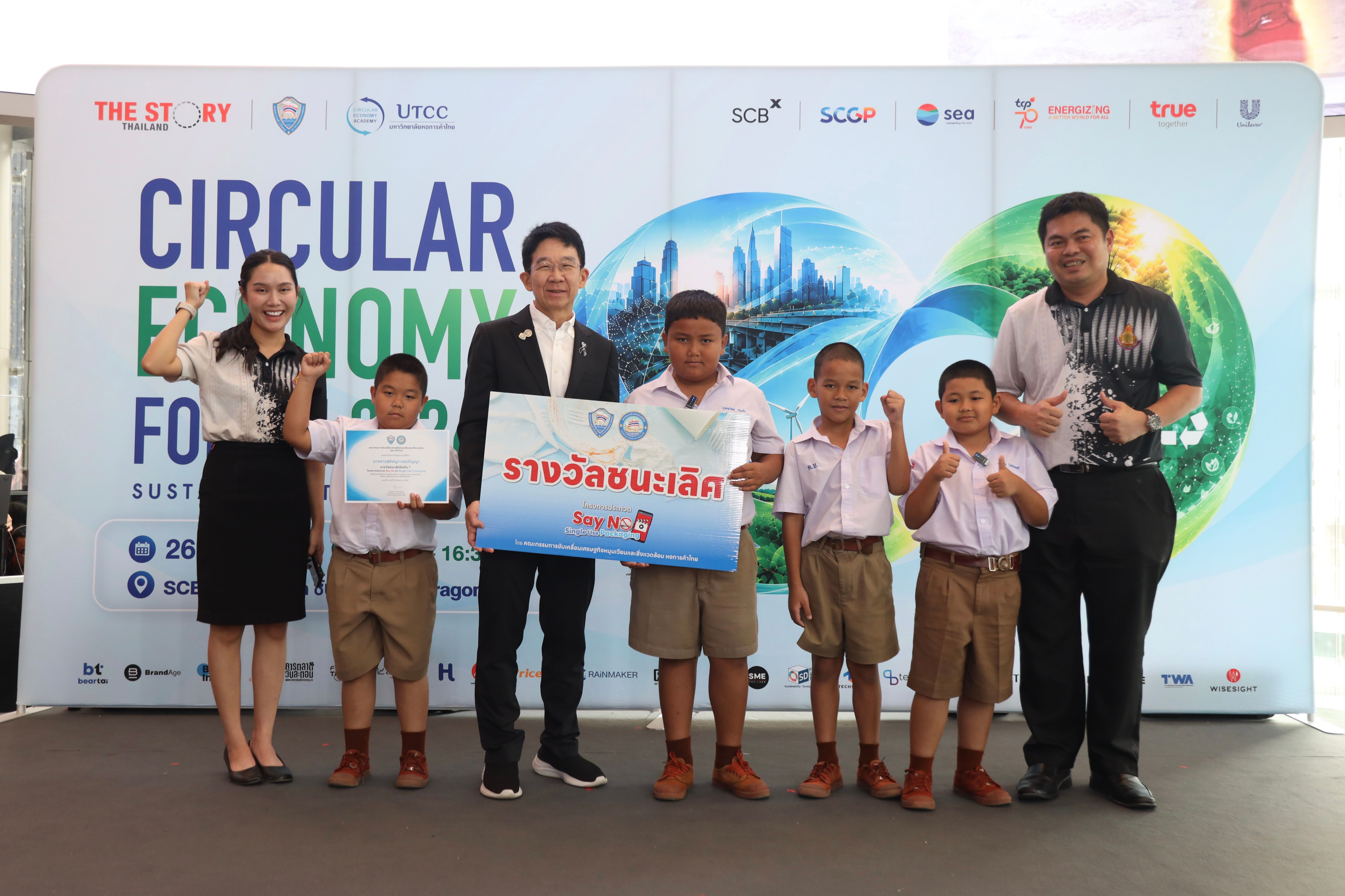 Group of adults and children holding an award banner at the Circular Economy Forum 2023.