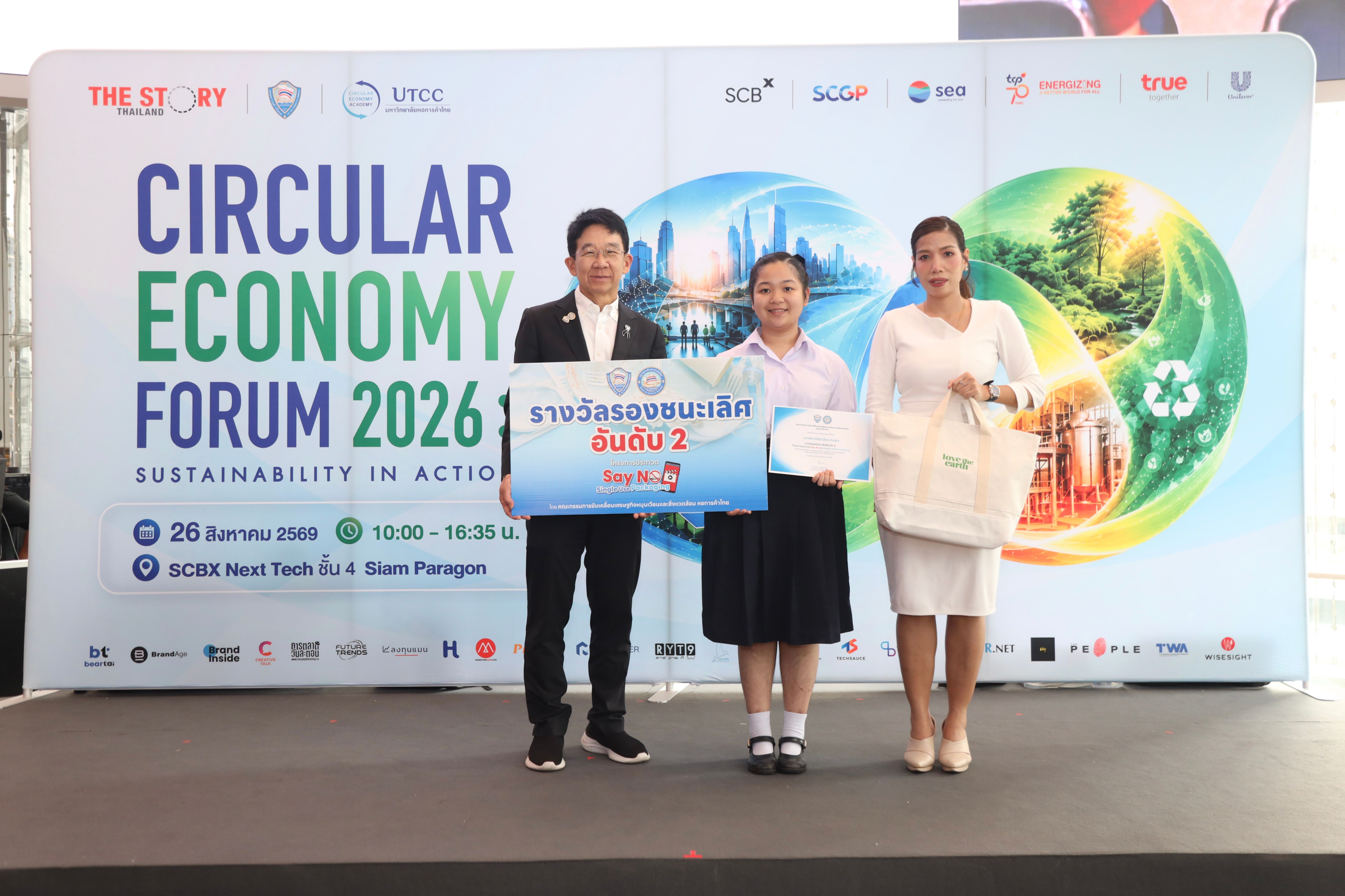 Three people, including a student, on stage at a Circular Economy Forum event.