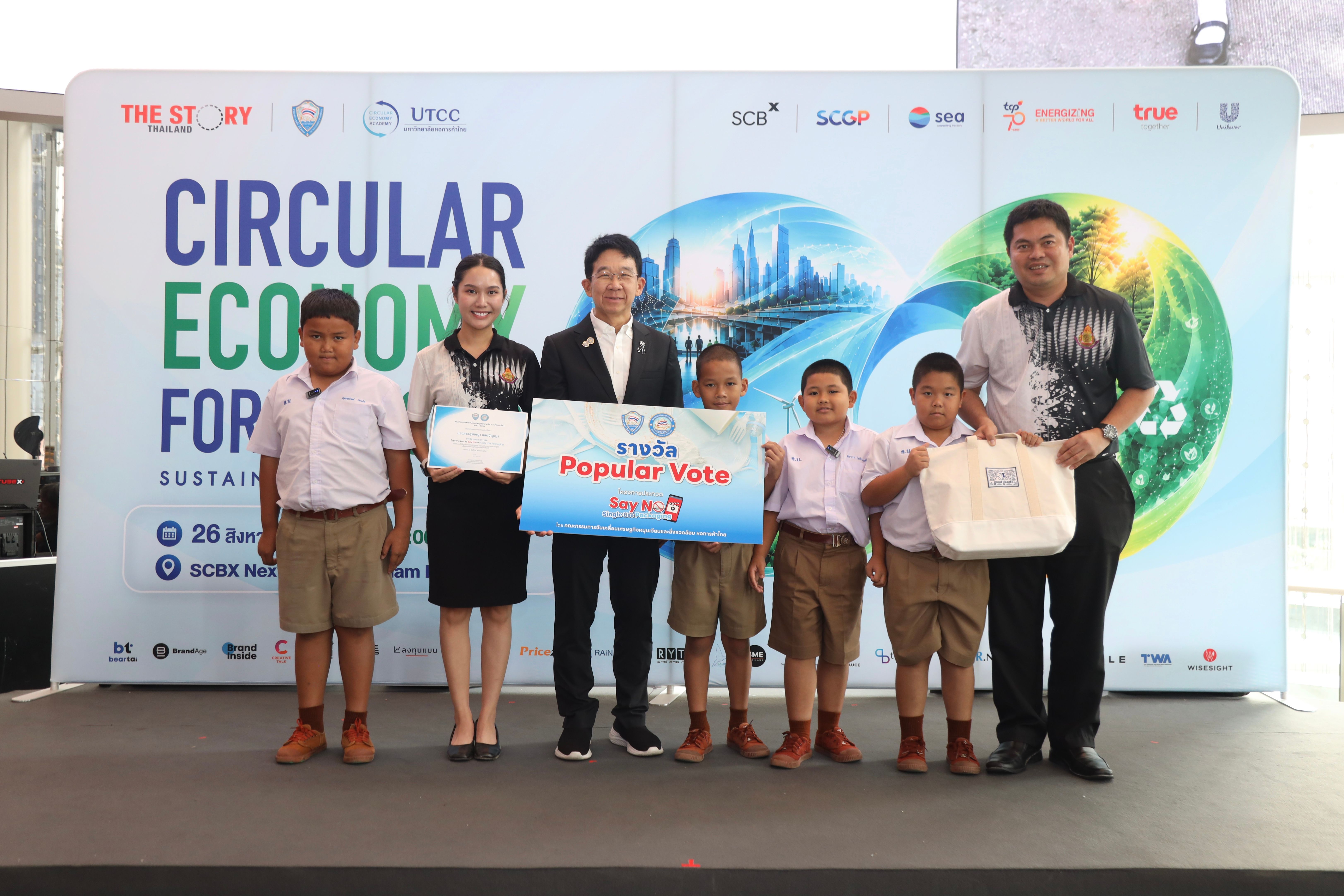 Adults and children hold awards at a "Circular Economy for Sustainability" event.