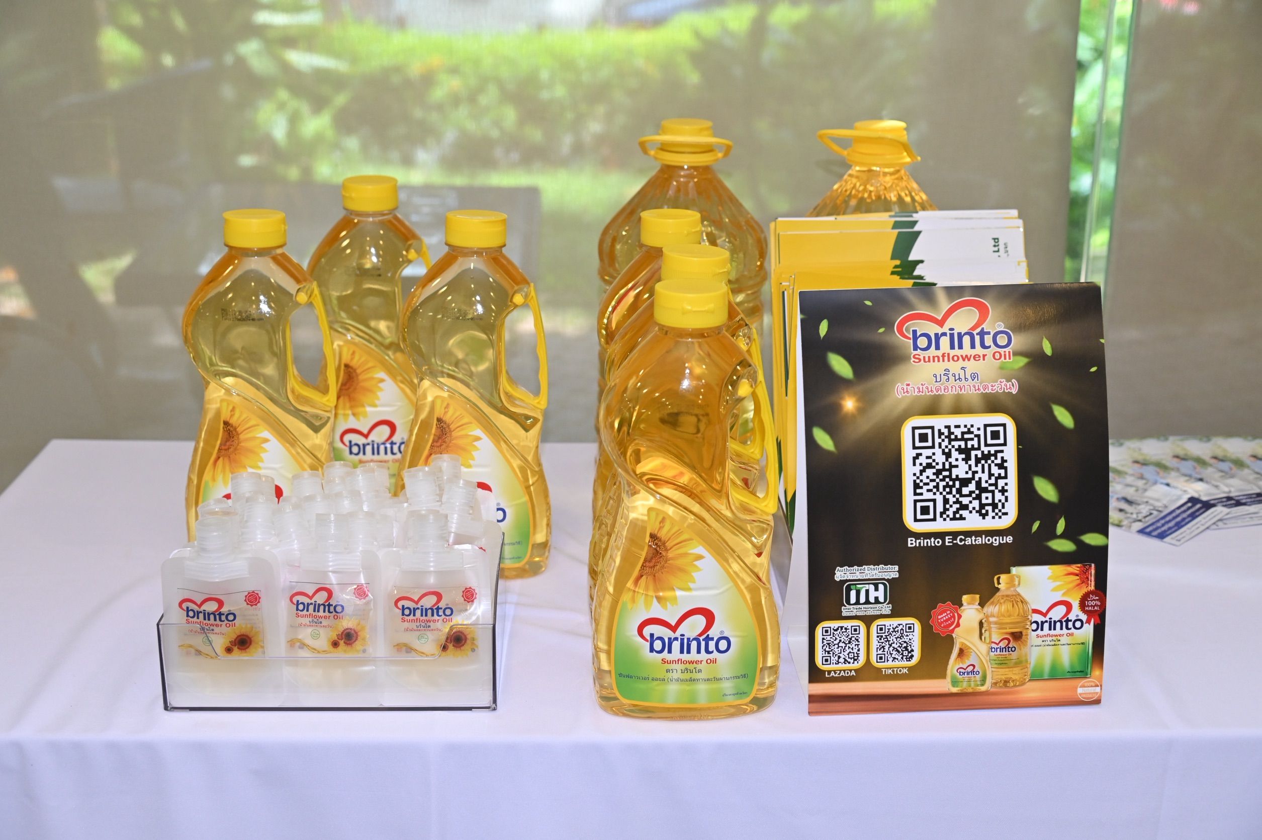 Bottles of Binnito sunflower cooking oil displayed on a white table with a QR code.