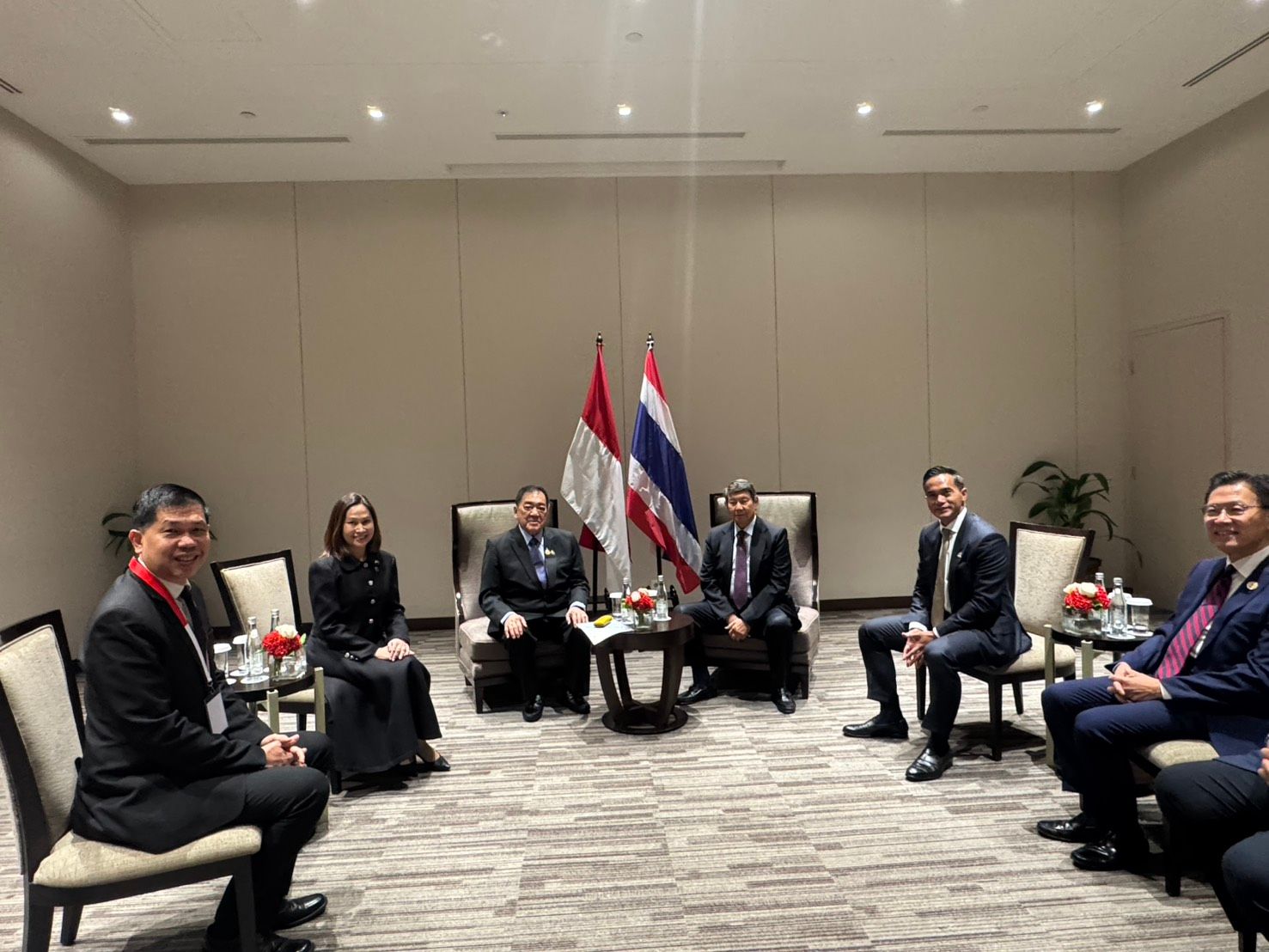 Delegates from Indonesia and Thailand seated in a formal meeting room with their national flags.