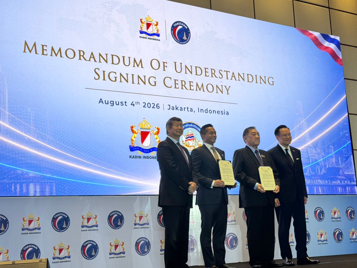 Four men present signed documents at a MOU ceremony in Jakarta.