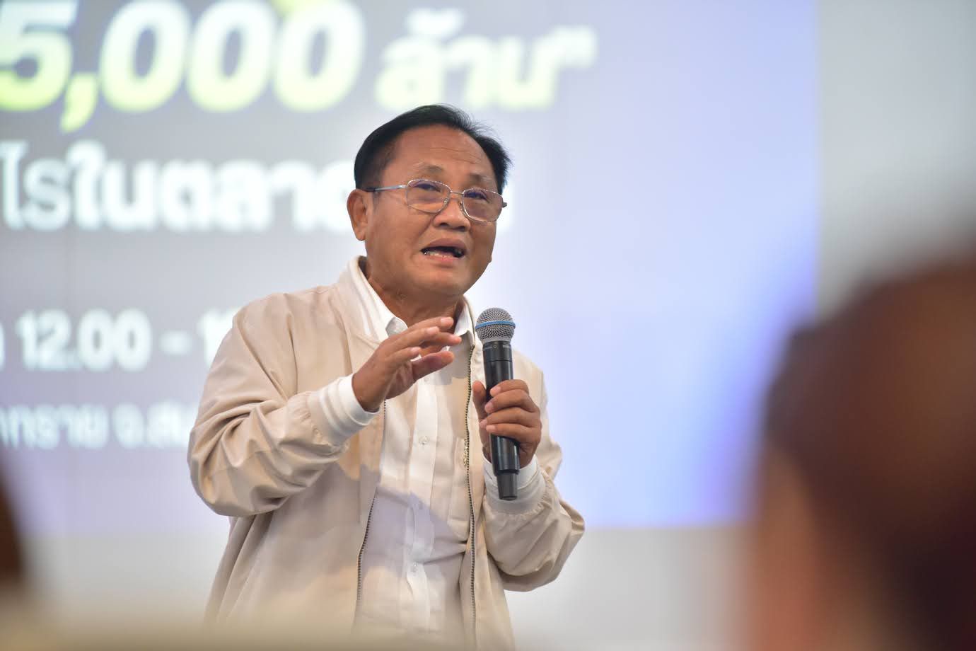 A man with glasses speaks passionately into a microphone during a presentation.