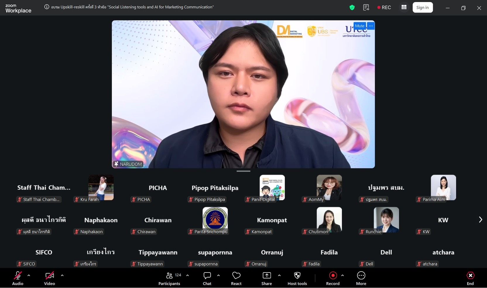 Young man in a blue jacket speaks during an online video conference.