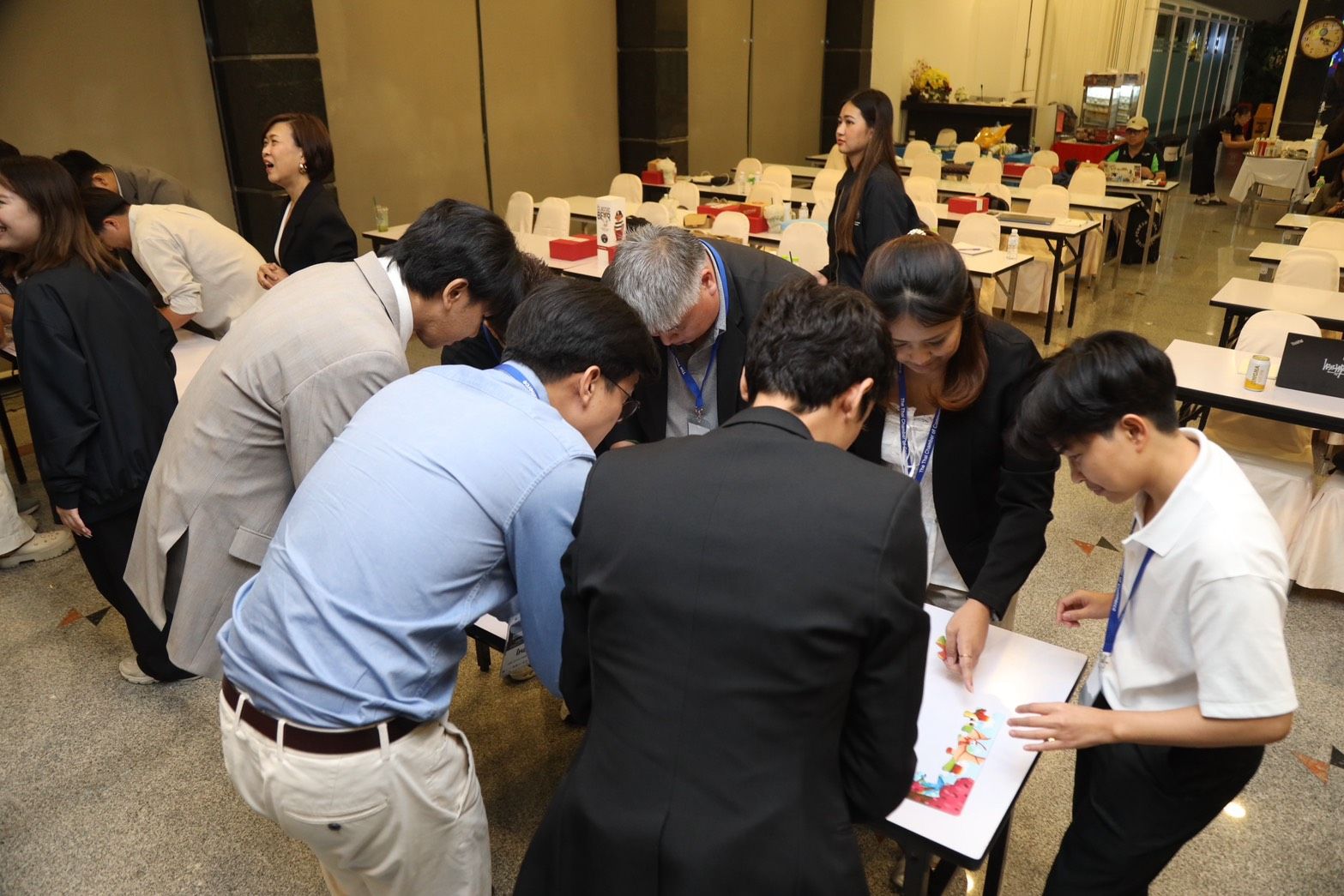 Group of professionals collaboratively examining documents on a table during a workshop.