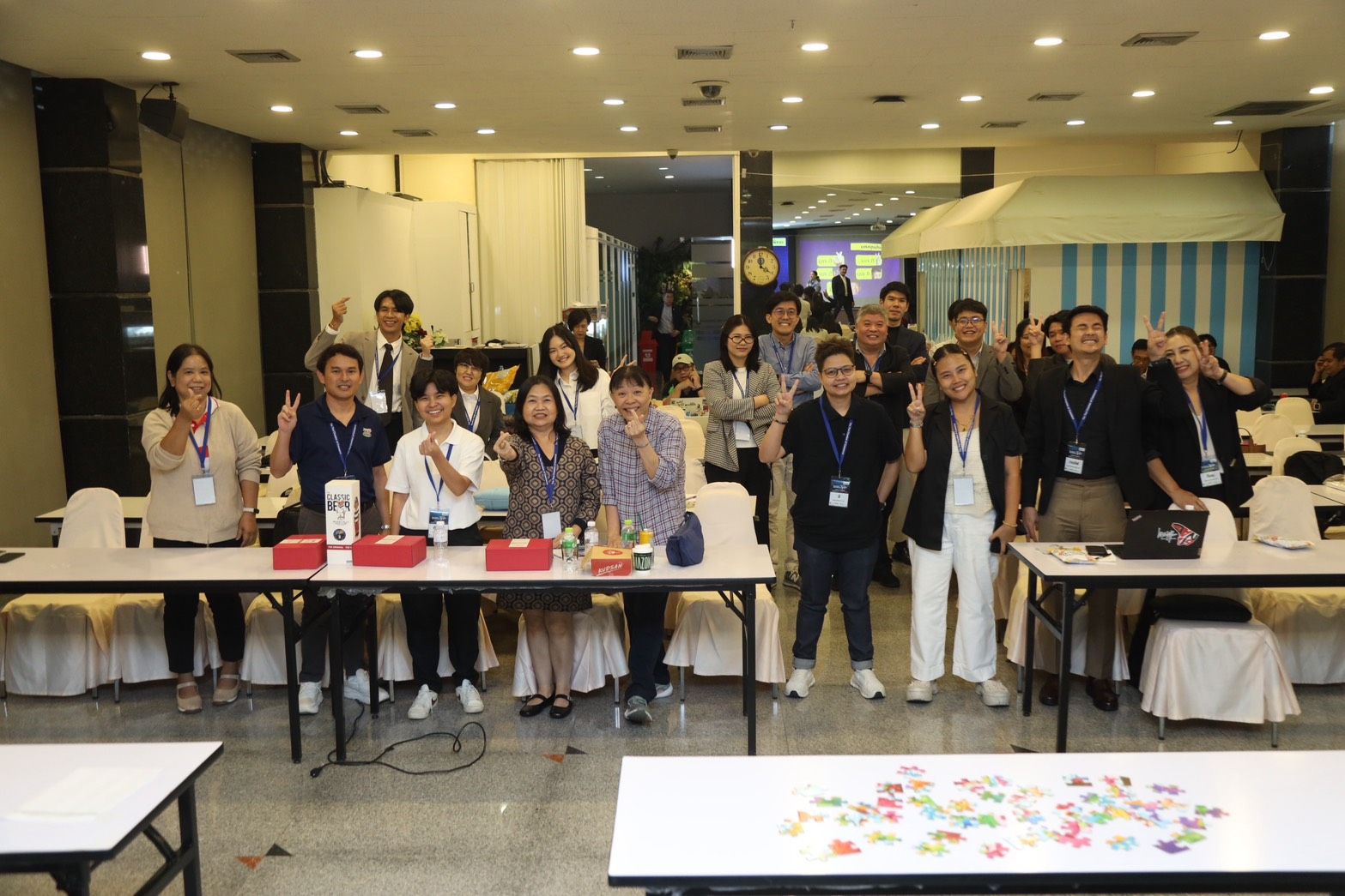 Smiling group of professionals raising hands enthusiastically during an indoor event.