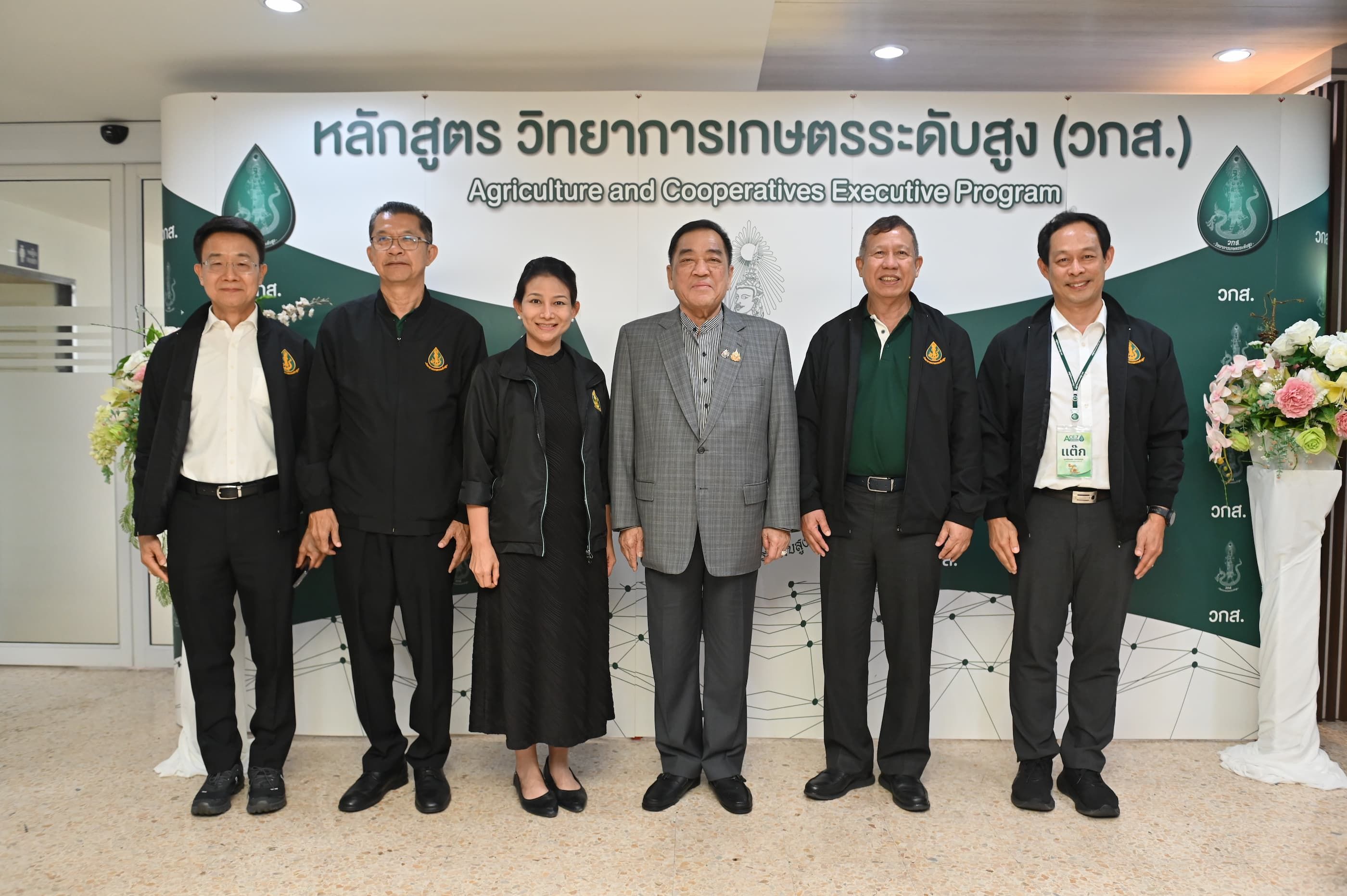 Six officials pose in front of an 'Agriculture and Cooperative Promotion Program' banner.