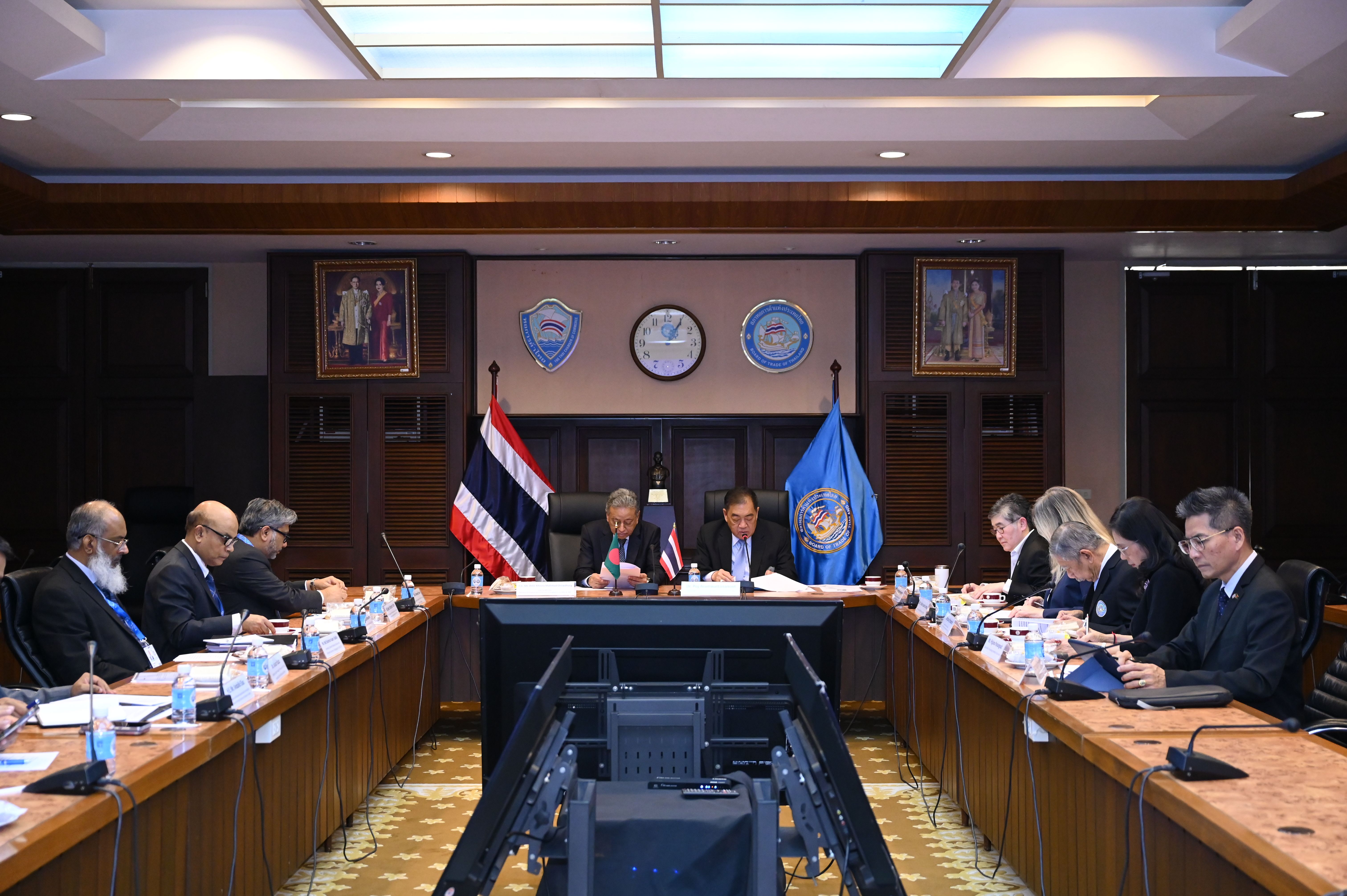 Officials and delegates attend a formal meeting around a large U-shaped conference table.
