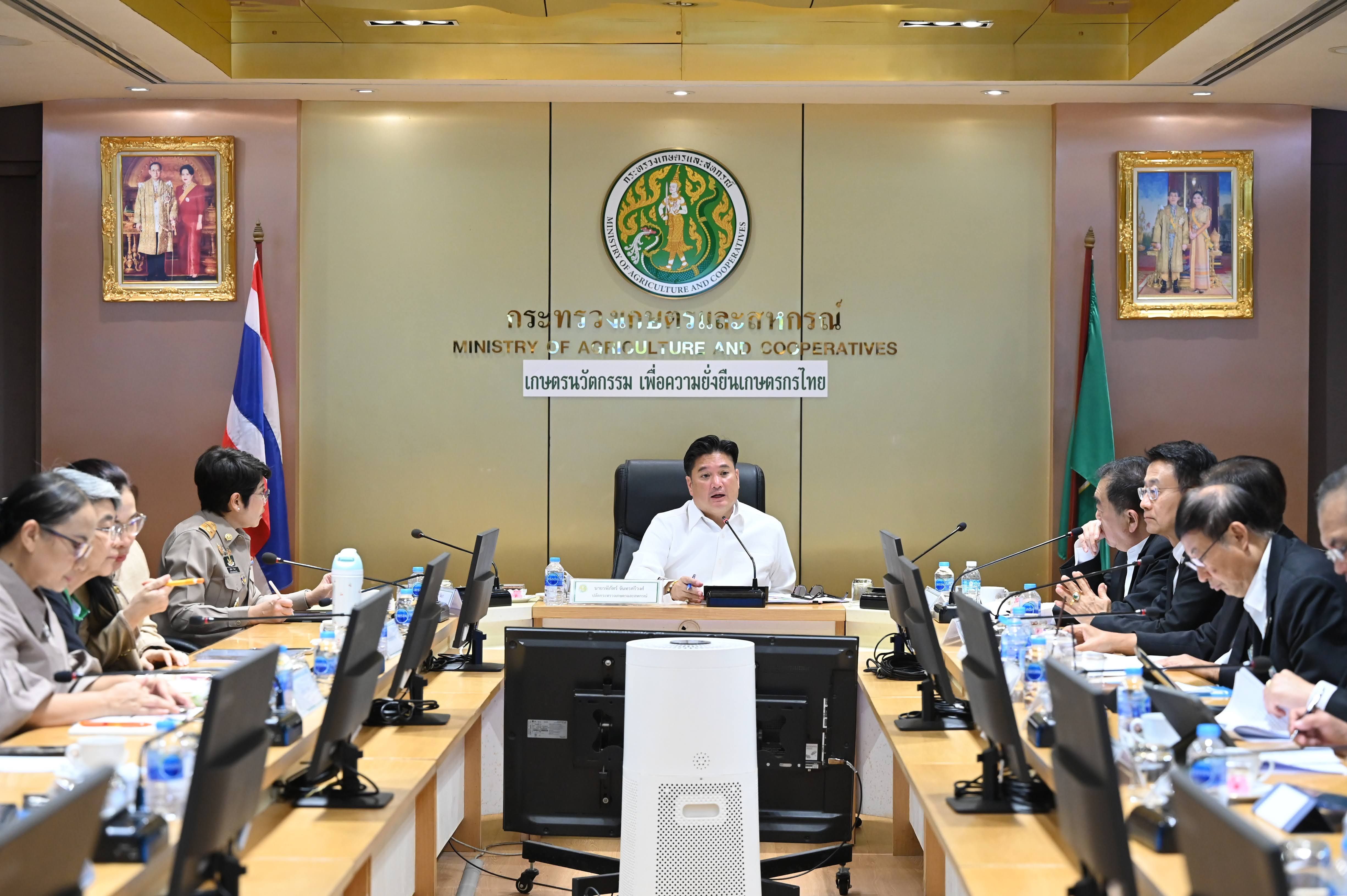 A man presides over a meeting with officials around a large conference table.